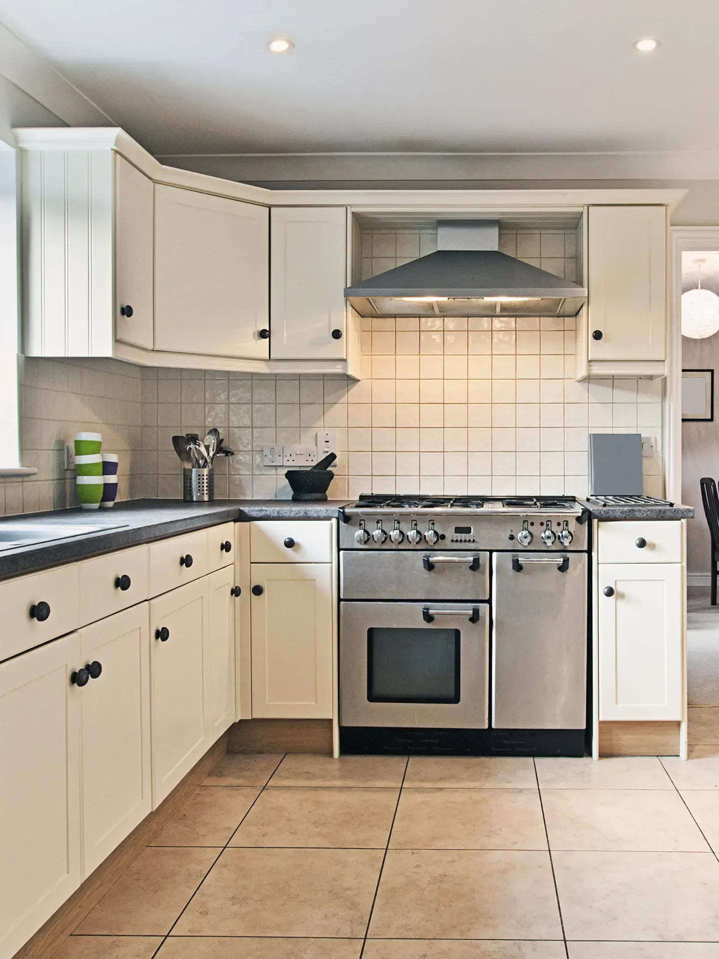 Une cuisine avec des appareils en acier inoxydable et des armoires blanches