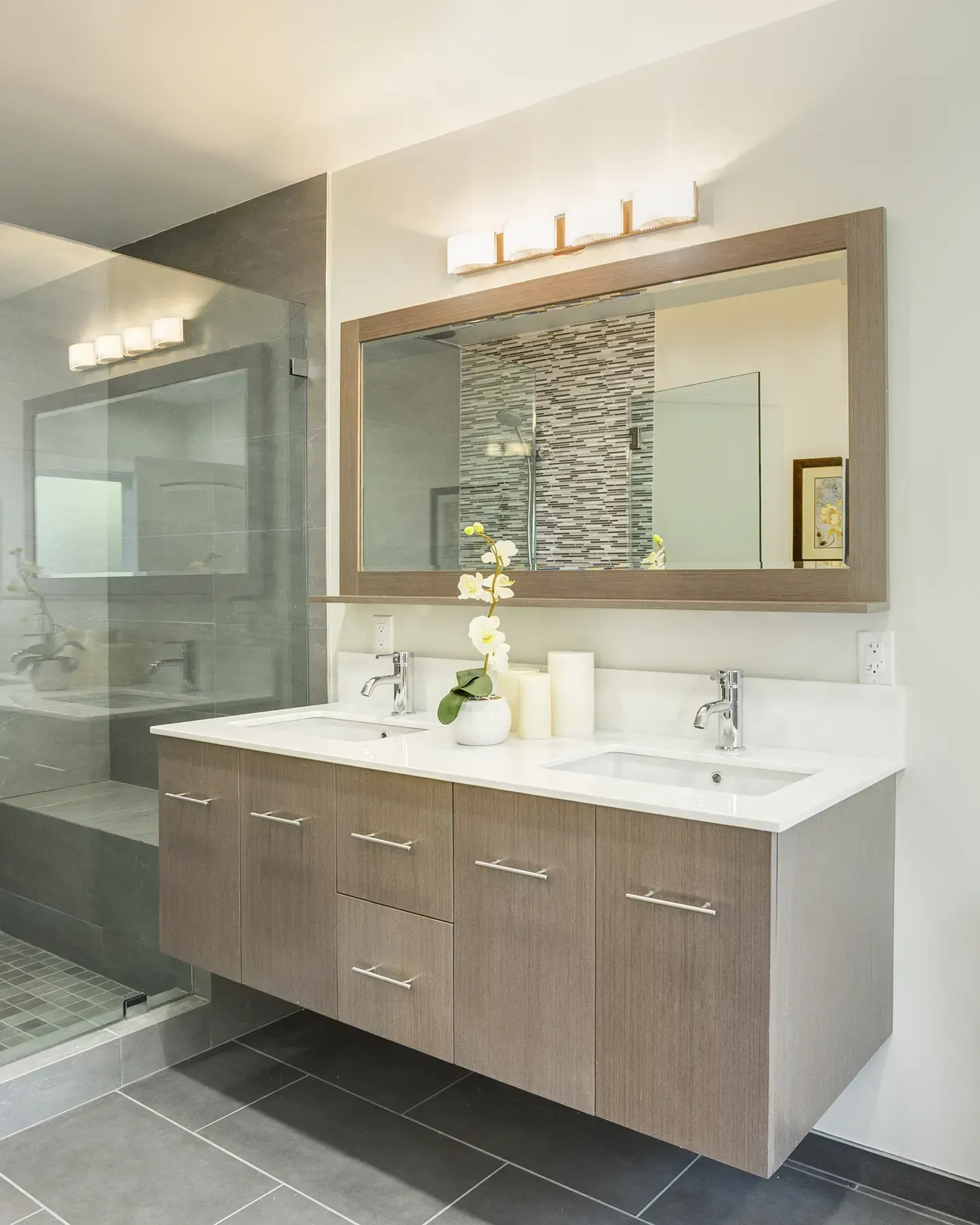 Une salle de bain avec deux lavabos et un grand miroir