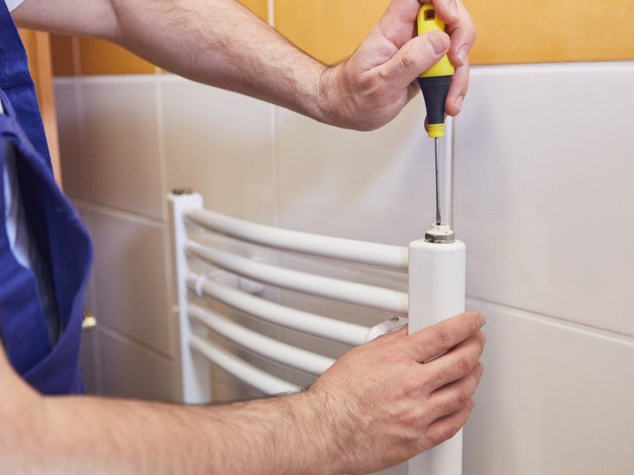 Derbyshire Plumbing & Heating Specialists bleeding a new towel radiator installed in Derby