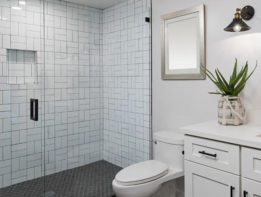 Derbyshire Plumbing & Heating Specialists wet room with white tiling installed in Derby