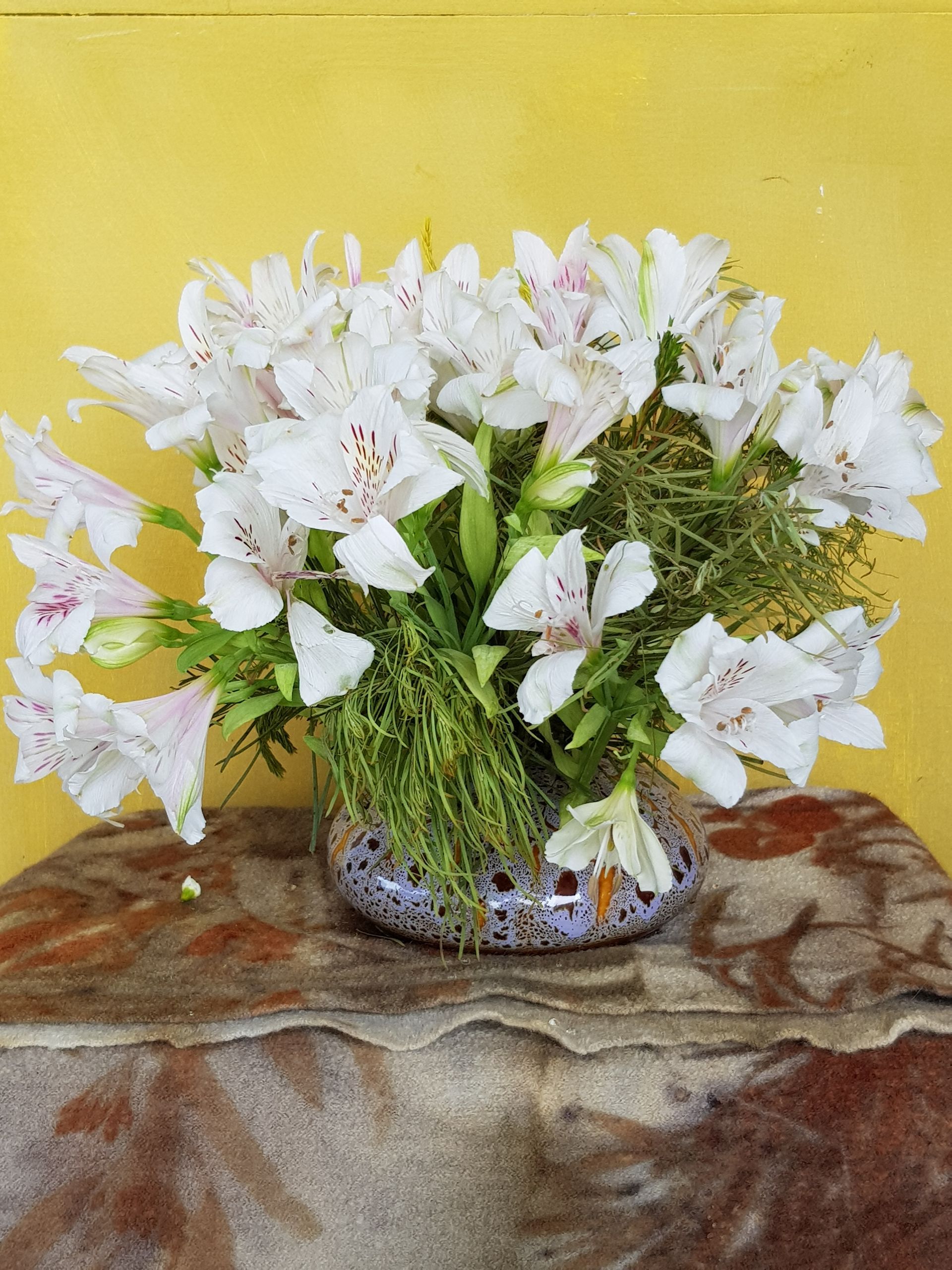 A PoseyPot filled with white flowers sits on a table