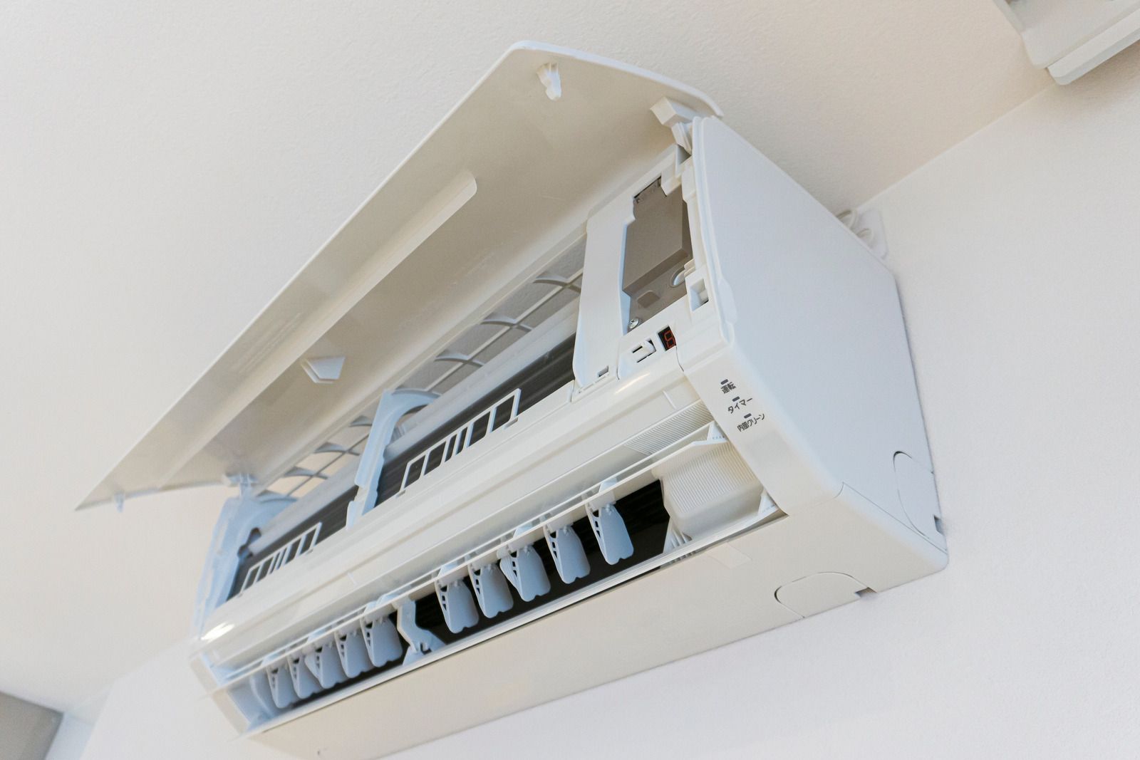 A white air conditioner is hanging from the ceiling in a room.