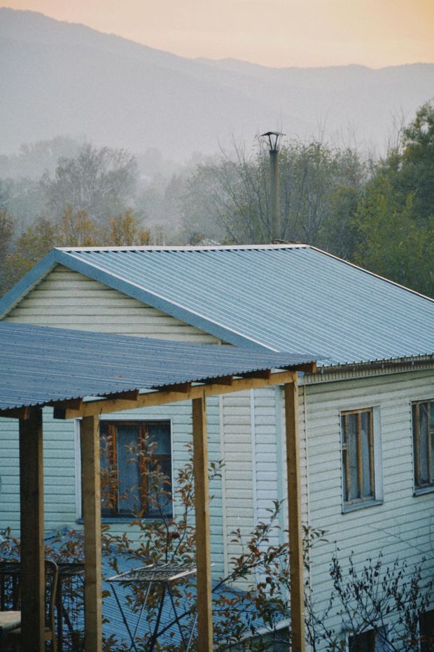 A white house with a metal roof and a porch.