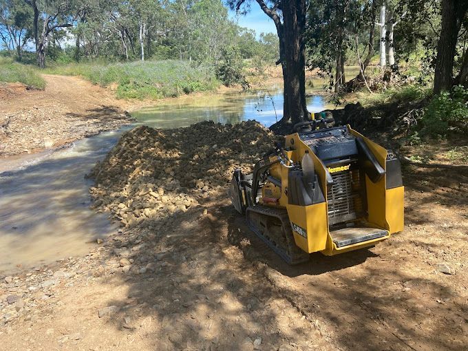 A Bulldozer and a Roller Are Working on a Dirt Road — RCJJ Mini Loaders In Mareeba, QLD