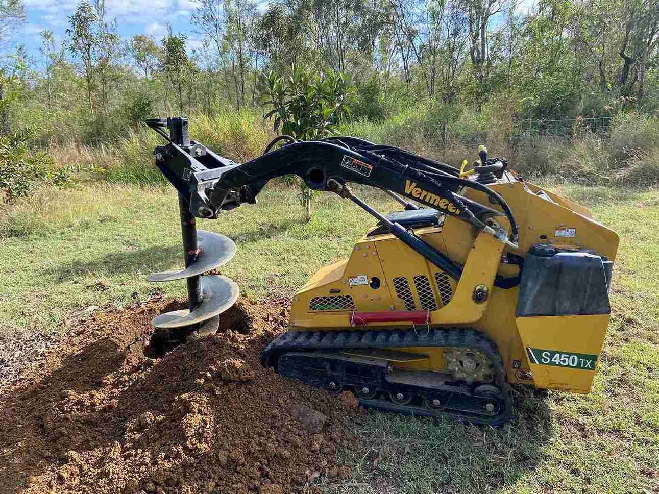 A Close Up of a Drill Bit Digging a Hole in the Ground — RCJJ Mini Loaders In Mareeba, QLD