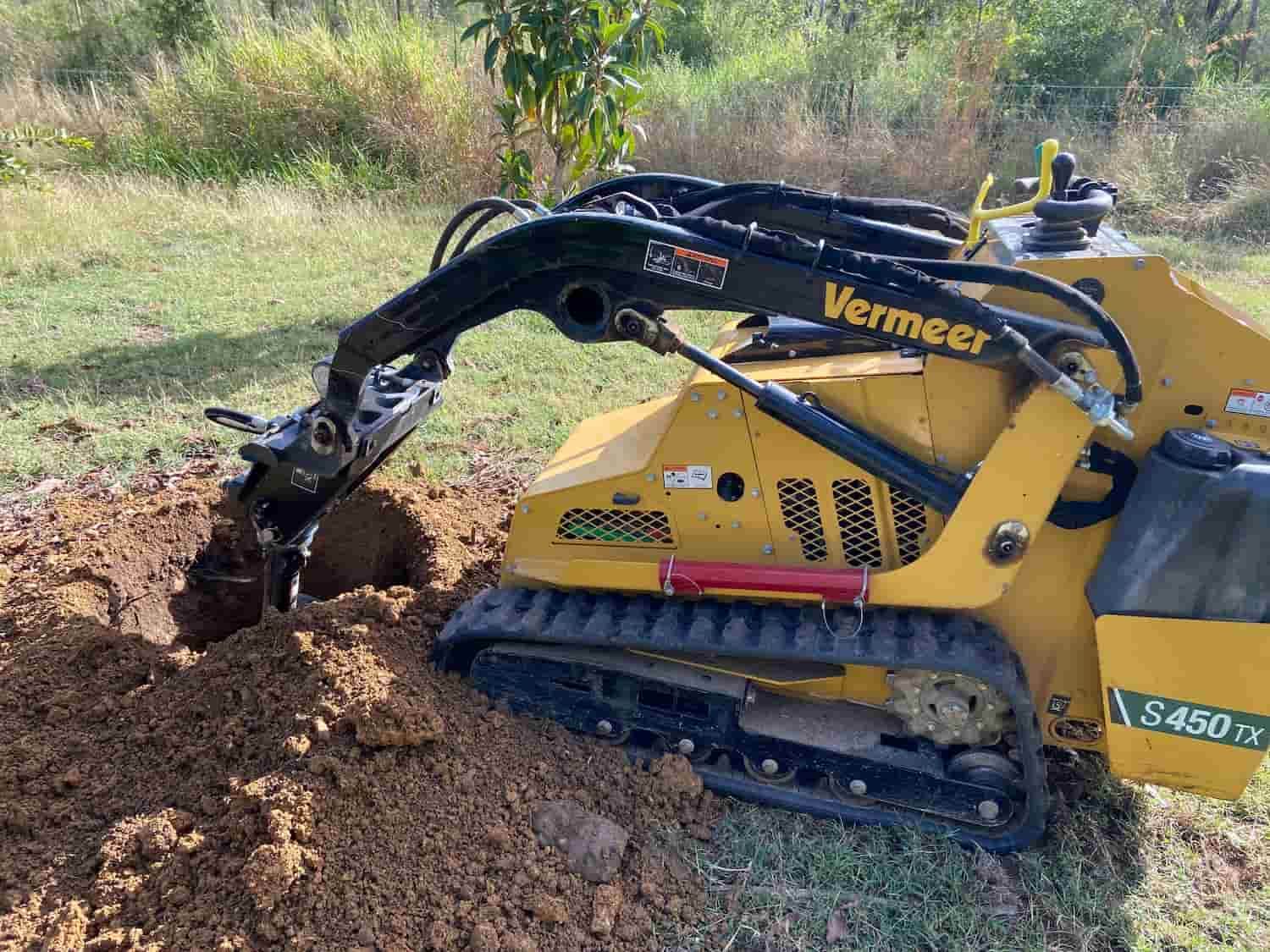 A Small Yellow Machine is Digging a Hole in the Ground — RCJJ Mini Loaders In Mareeba, QLD