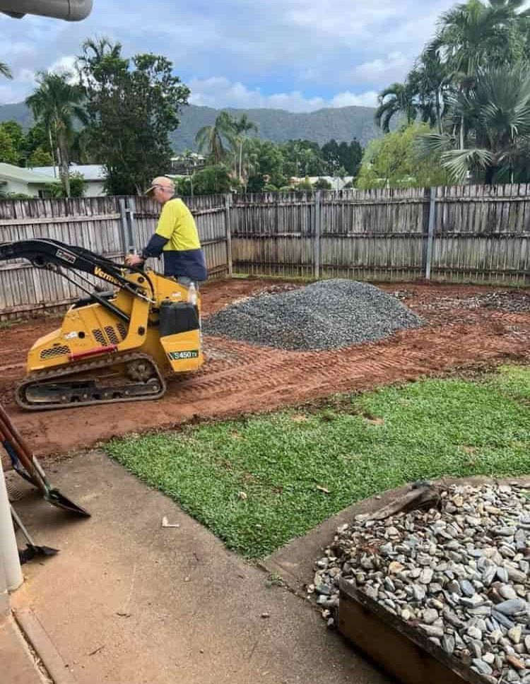 A Man is Riding a Bulldozer in a Backyard — RCJJ Mini Loaders In Mareeba, QLD