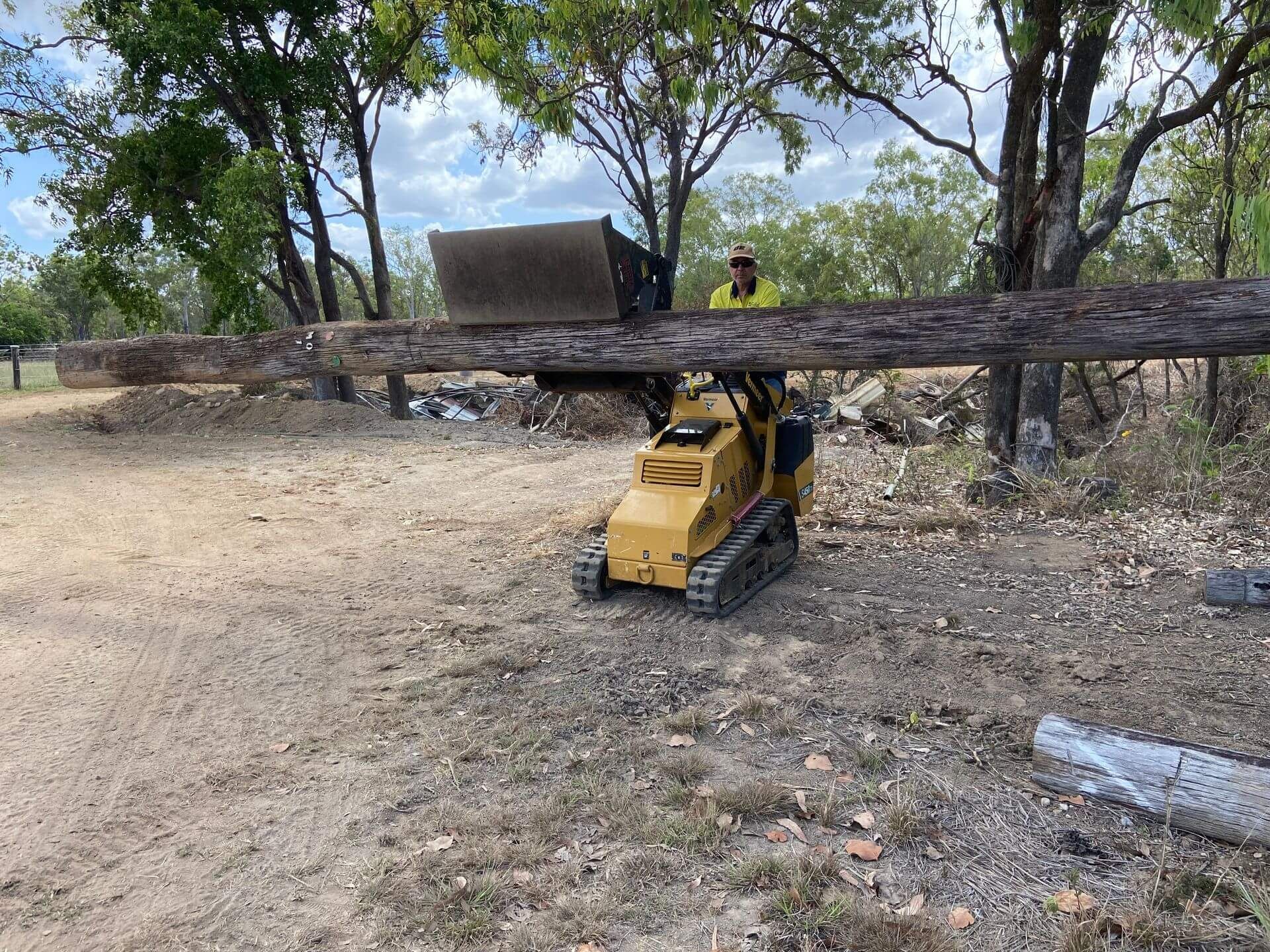 A Yellow Excavator is Digging a Pile of Dirt in a Field — RCJJ Mini Loaders In Mareeba, QLD