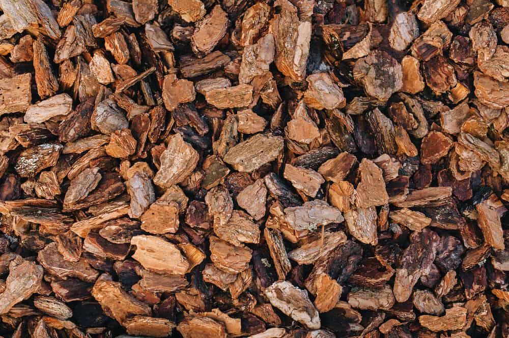 A Pile of Wood Chips Sitting on Top of Each Other — RCJJ Mini Loaders In Cairns, QLD