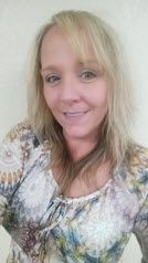 A woman in a floral shirt is smiling for the camera.