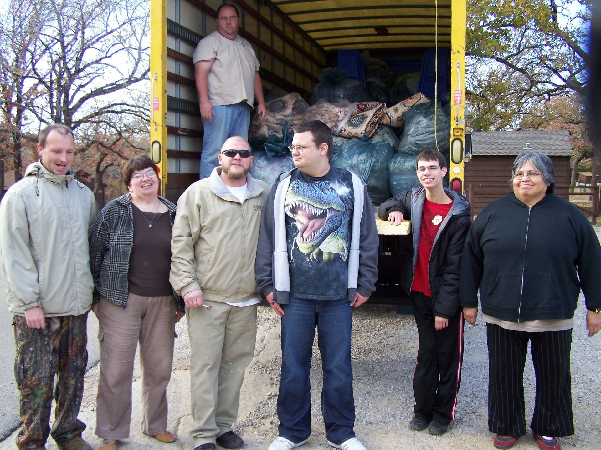 A group of people standing in front of a truck that has the number 0 on it