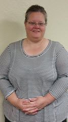 A woman in a striped shirt is standing with her hands on her hips.