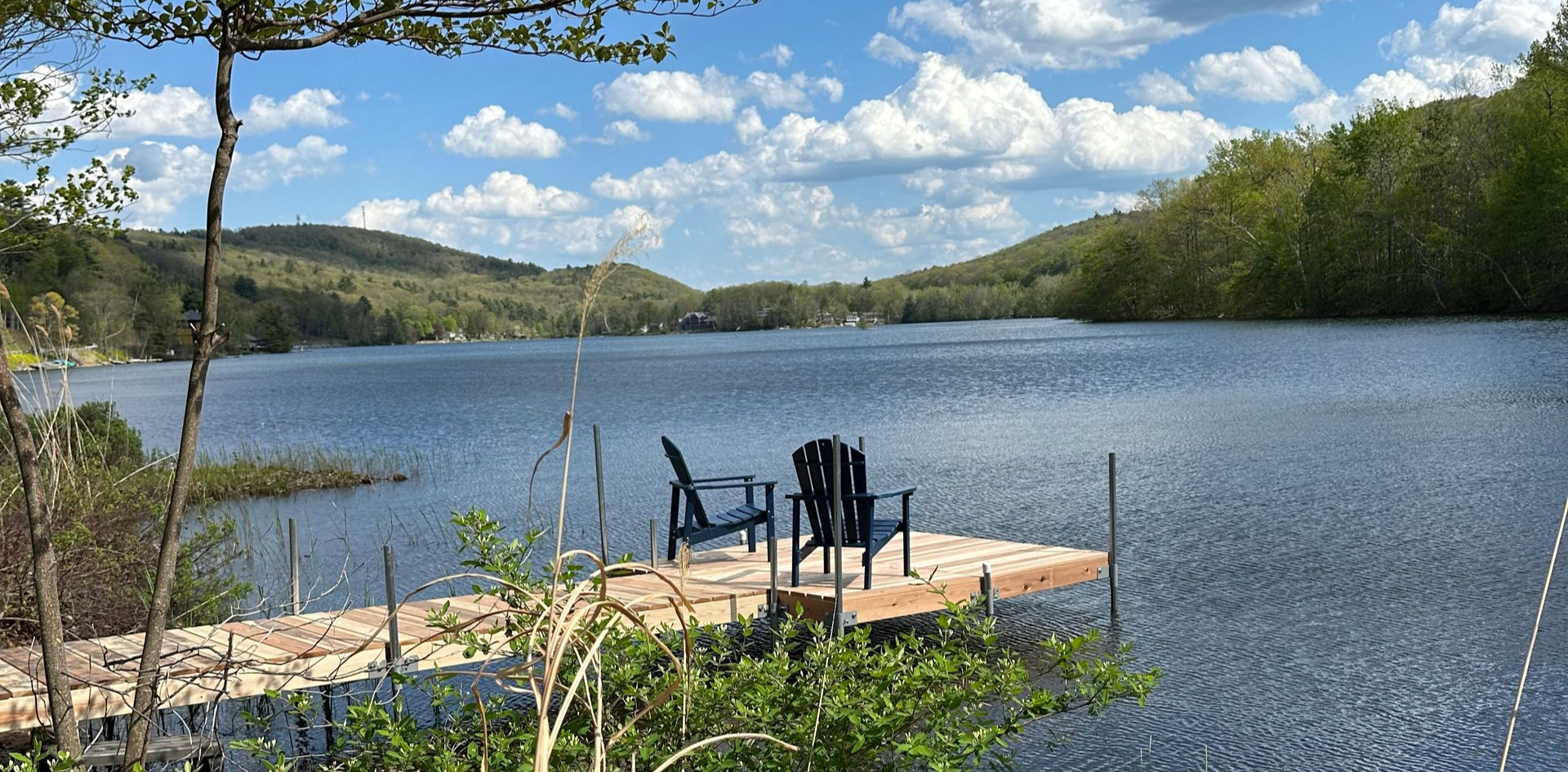 Adirondack chairs on a dock overlooking a lake in the Berkshire Mountains. 