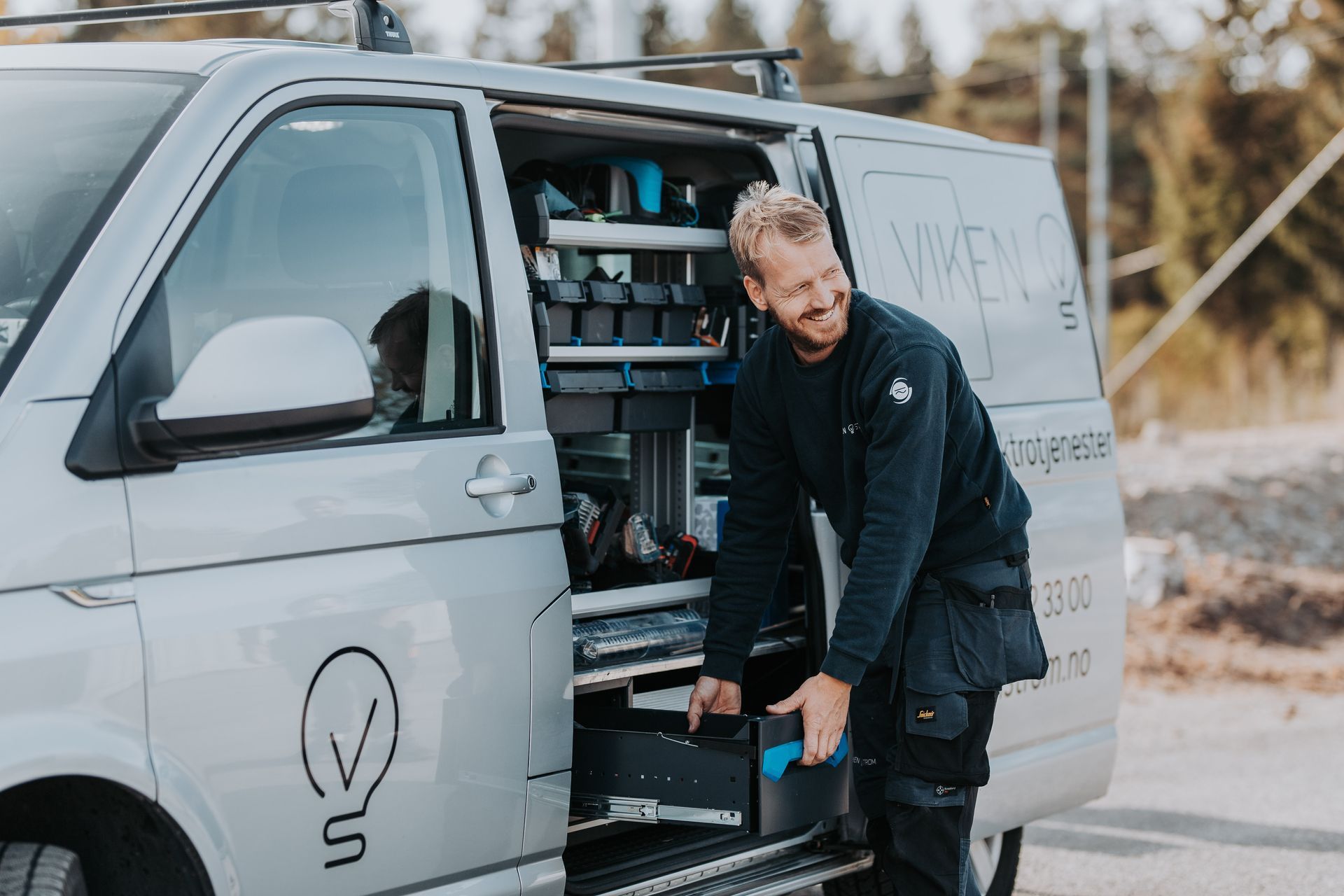 Elektriker henter utstyr i varebil