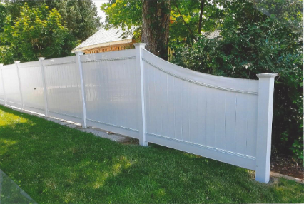 A white fence surrounds a lush green yard.