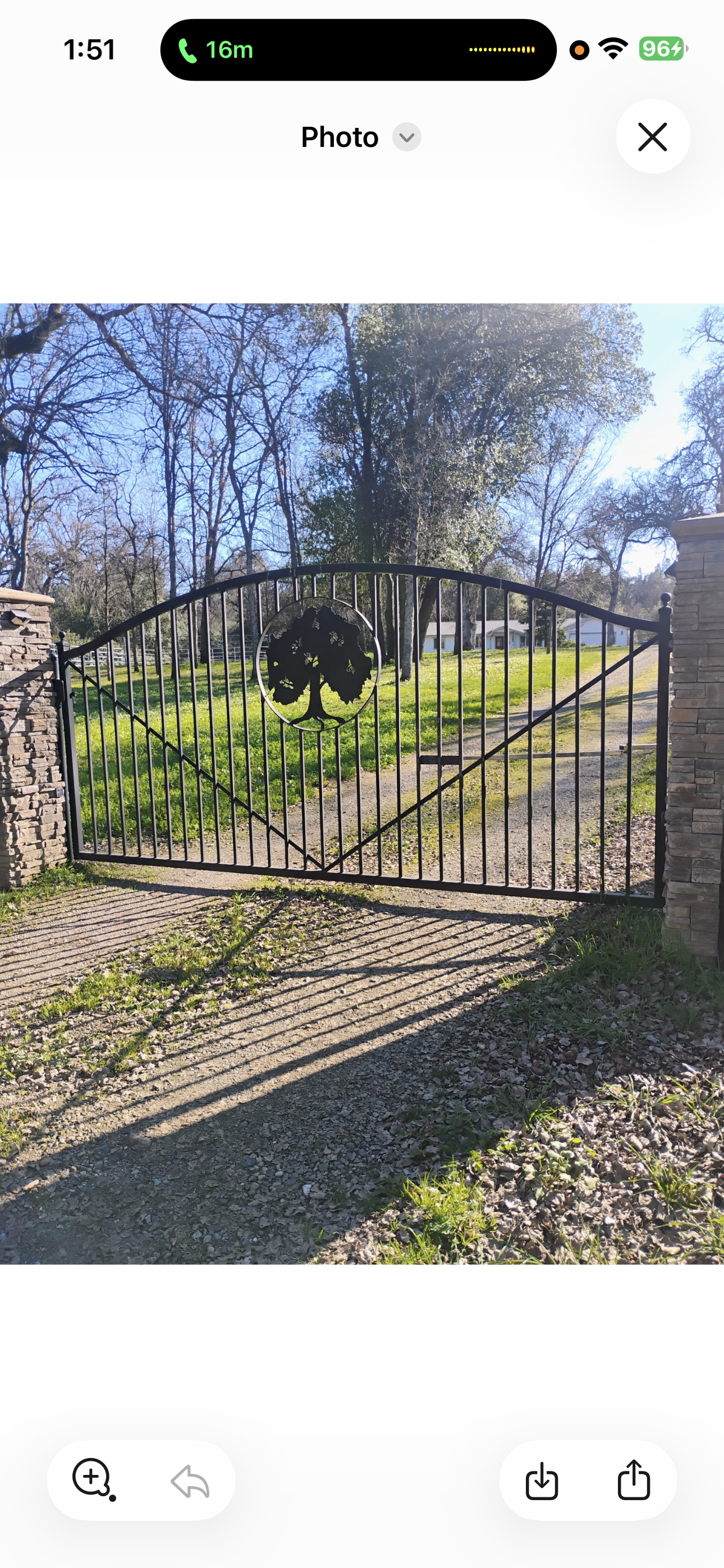 Wooden double gate, light brown, with metal hinges and lock, against a brick wall.