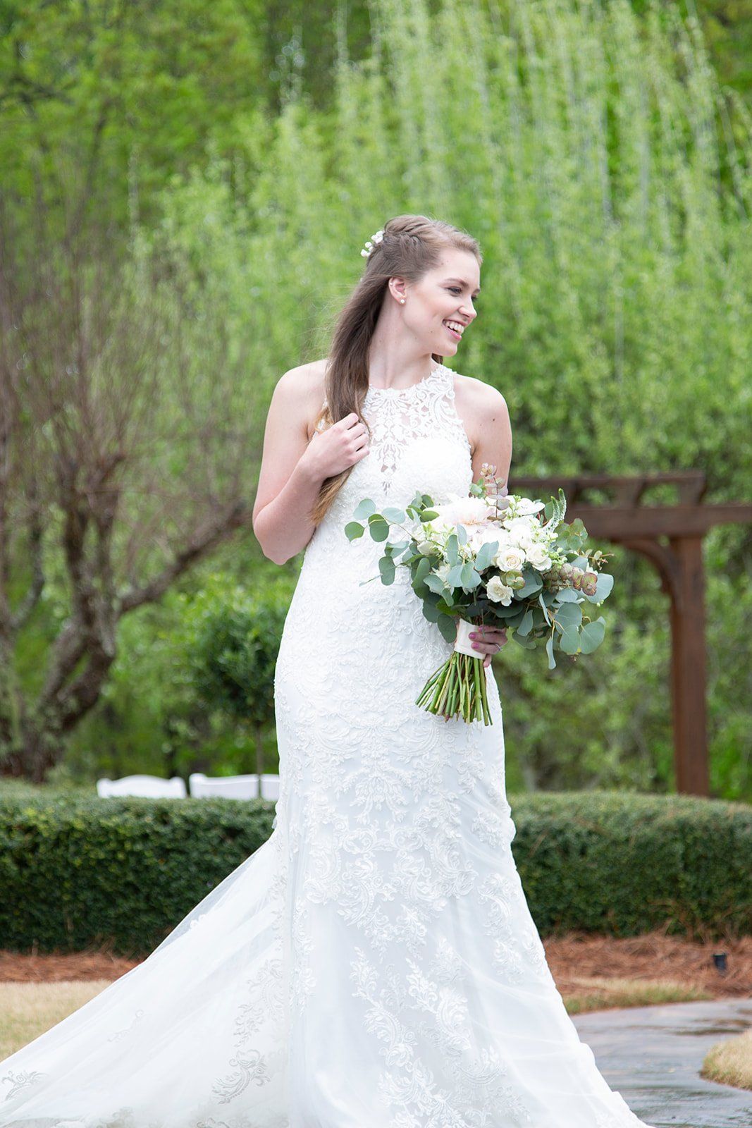A bride in a white wedding dress is holding a bouquet of flowers.