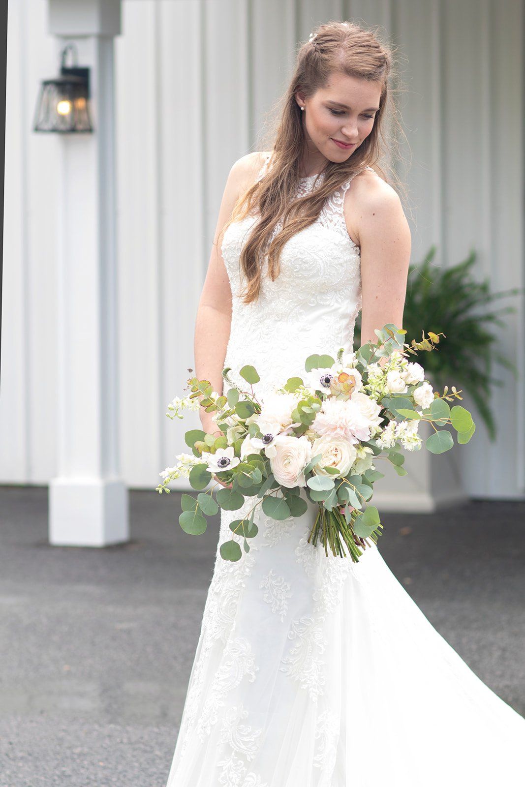 A bride in a wedding dress is holding a bouquet of flowers.
