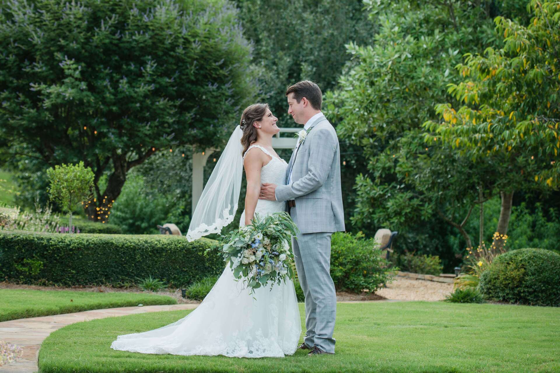 A bride and groom are posing for a picture in a garden.