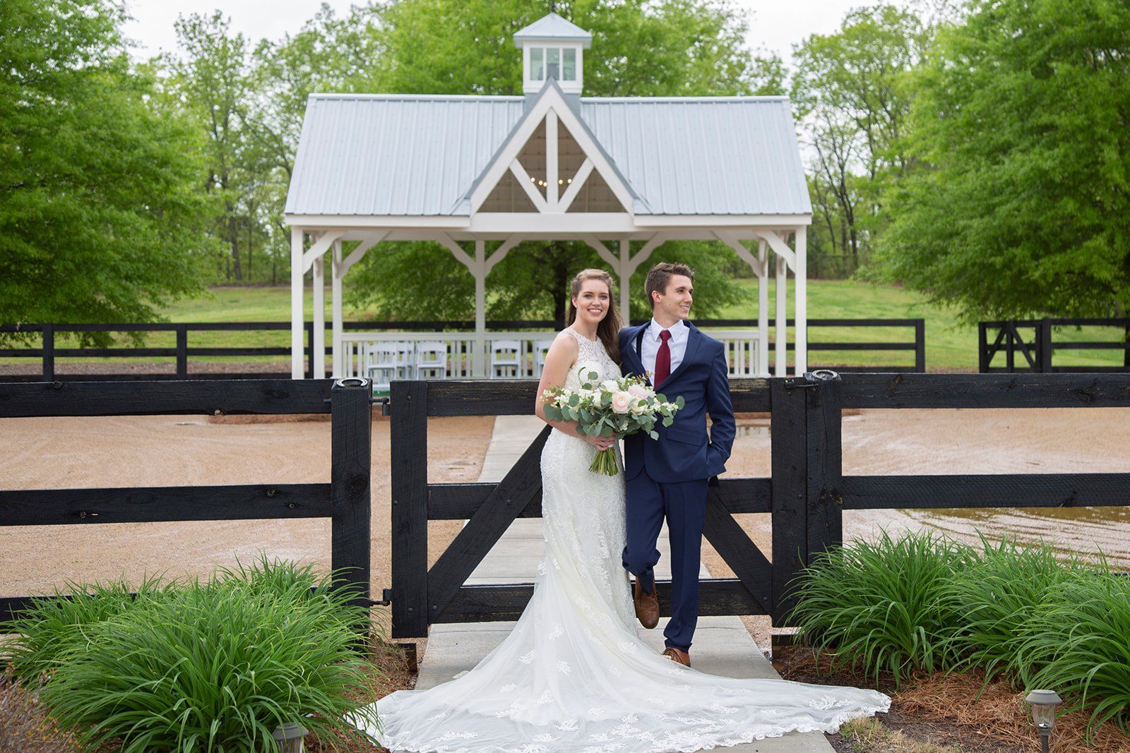 A bride and groom are posing for a picture in front of a gazebo.