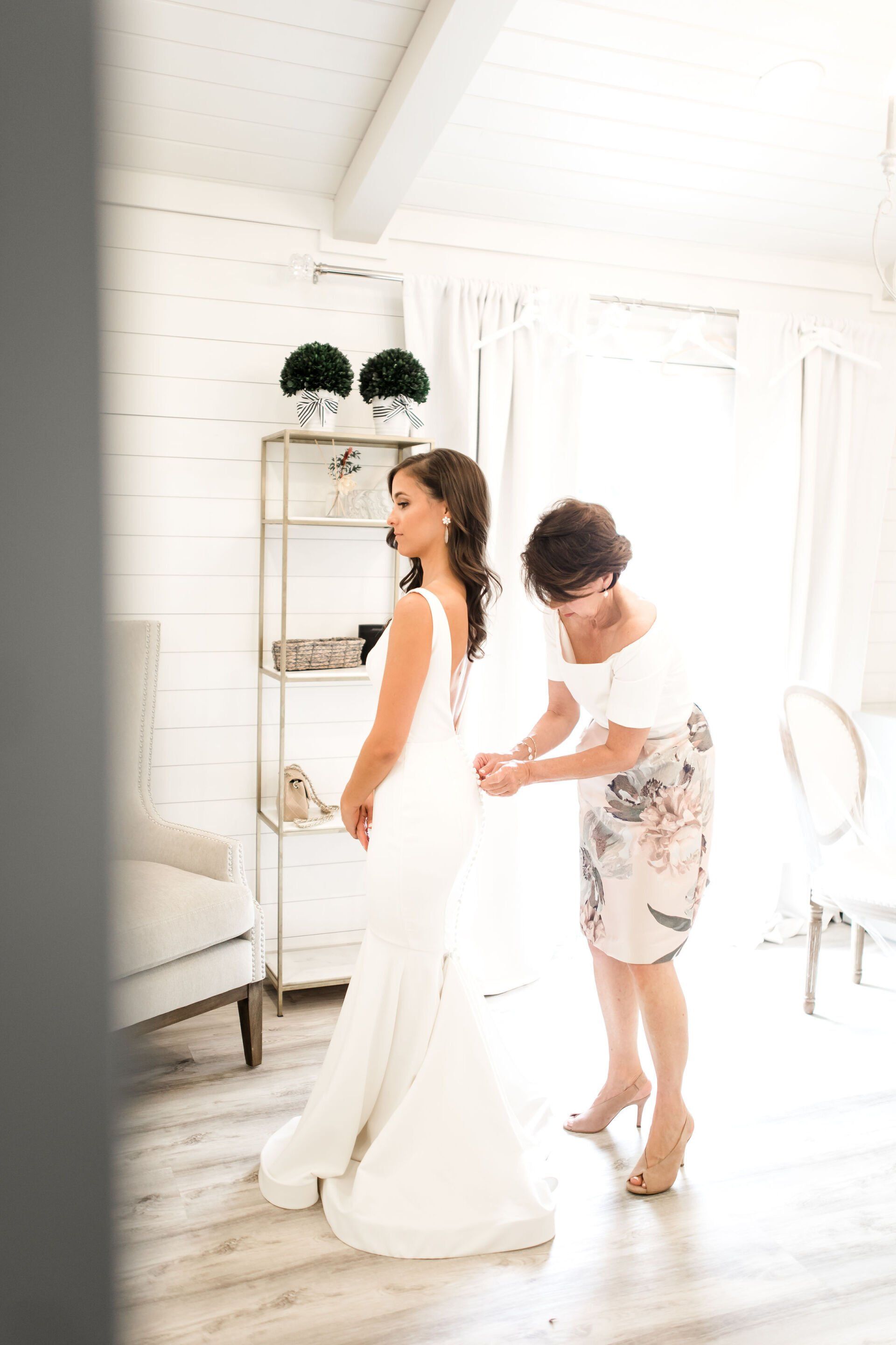 Bride adjusting gown in bridal suite