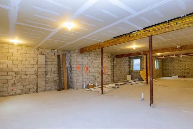 Dining room with exposed brick walls, wooden table, orange chairs, and pendant lights.