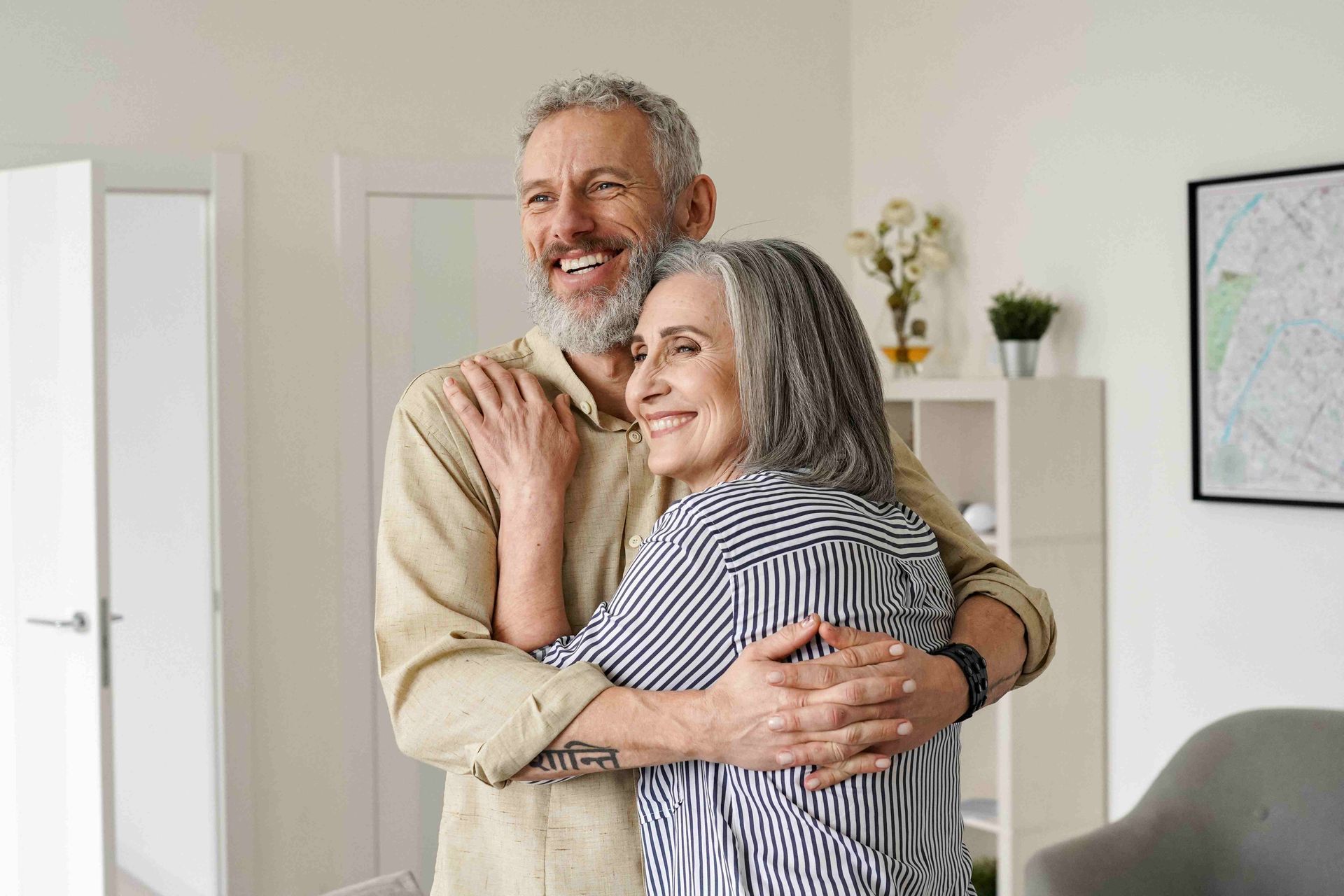 a man and woman are hugging and smiling in a living room