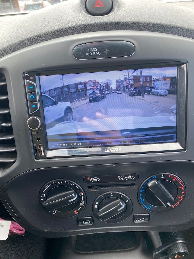 A car dashboard with a rear view camera and a radio.