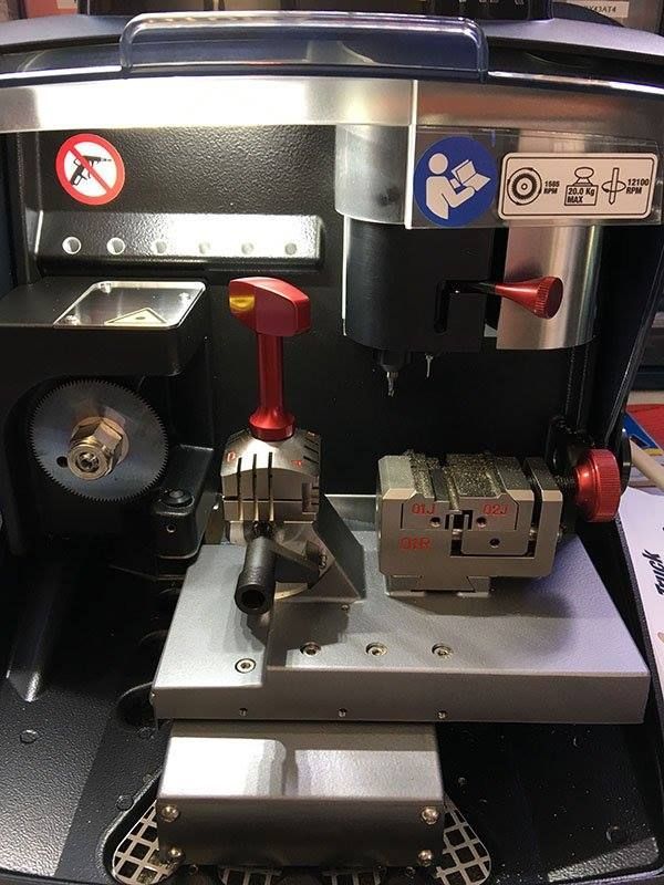 A key cutting machine is sitting on top of a table.