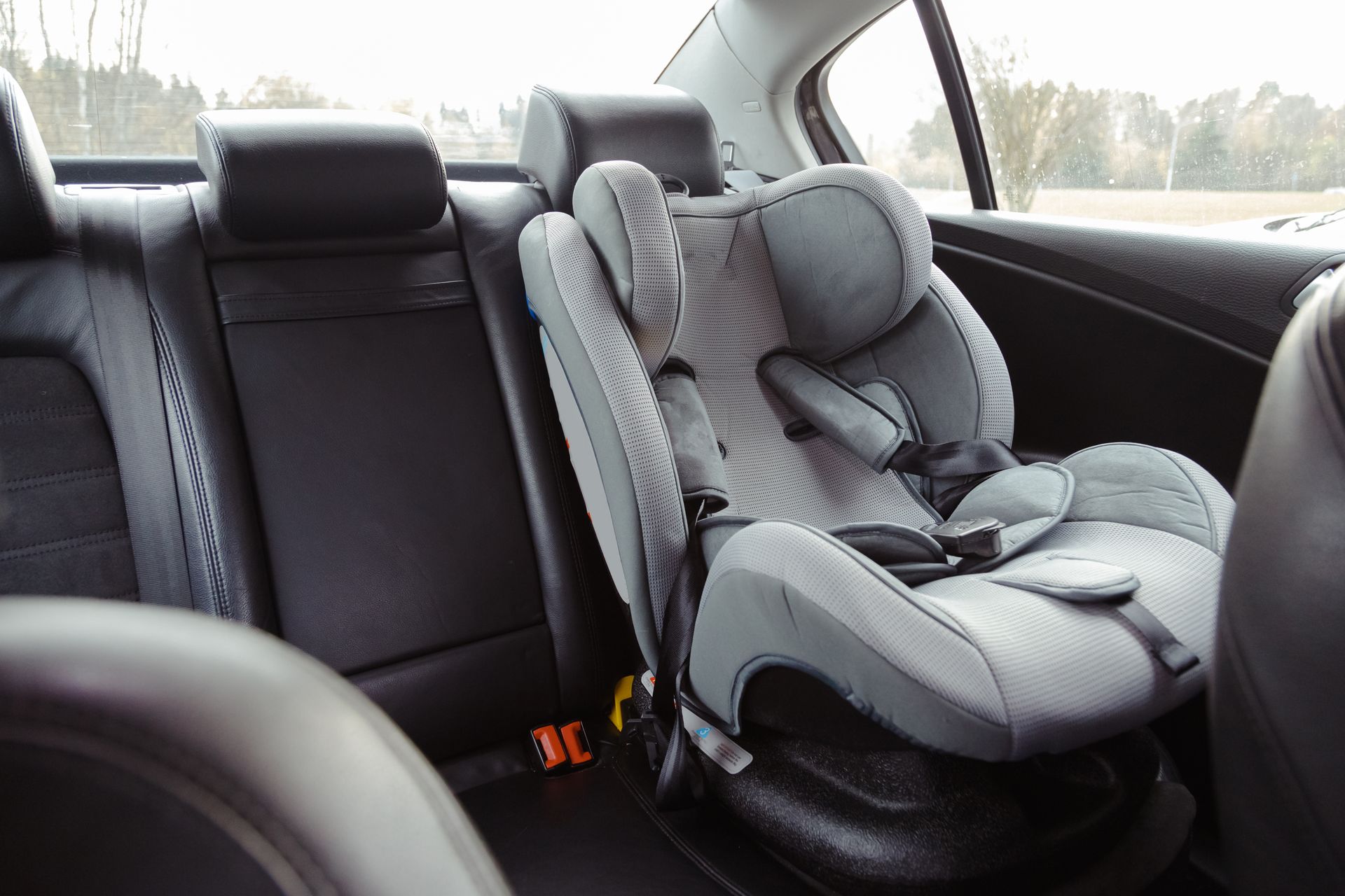 grey car seat in the back of the car that may have defects