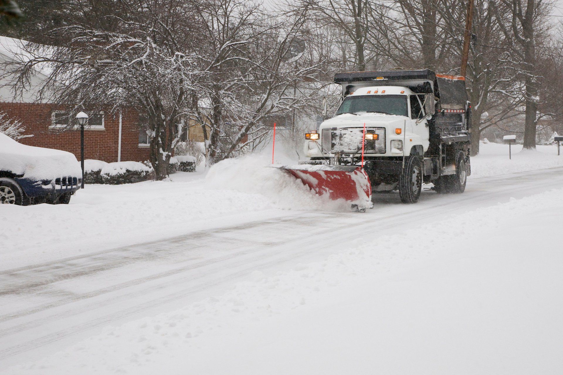 snow plow driving down snowy road