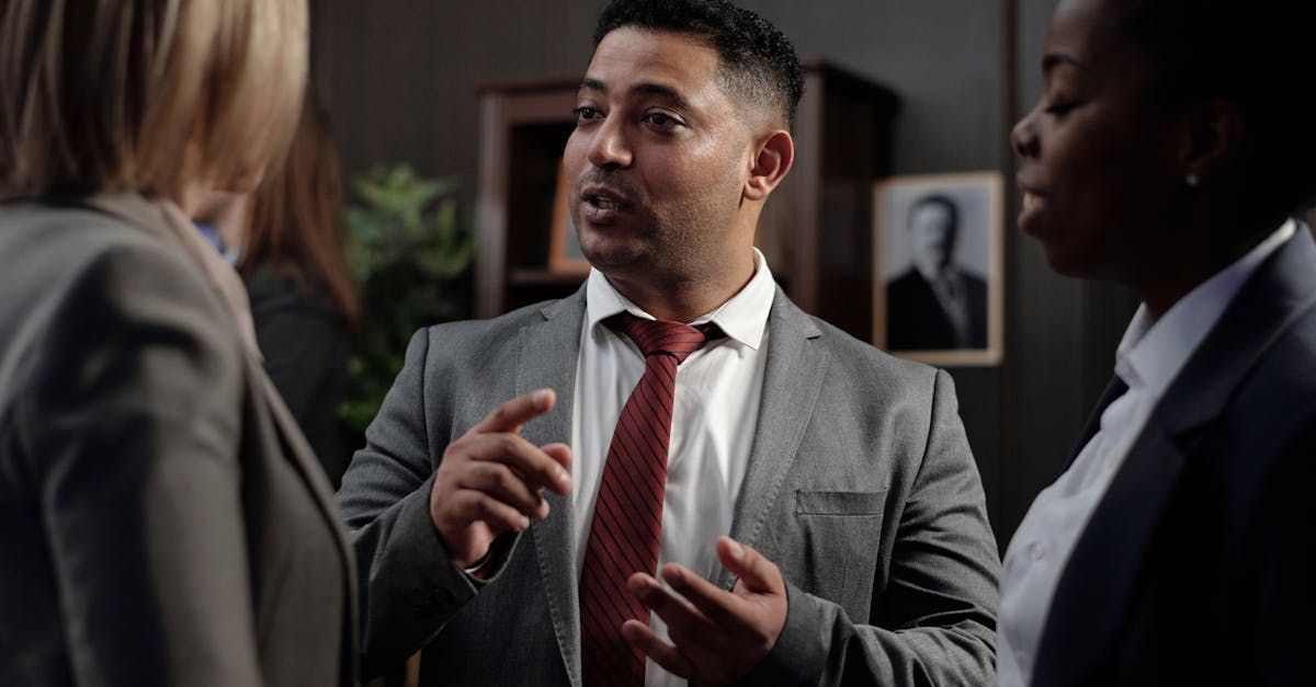 A man in a suit and tie is talking to two women.