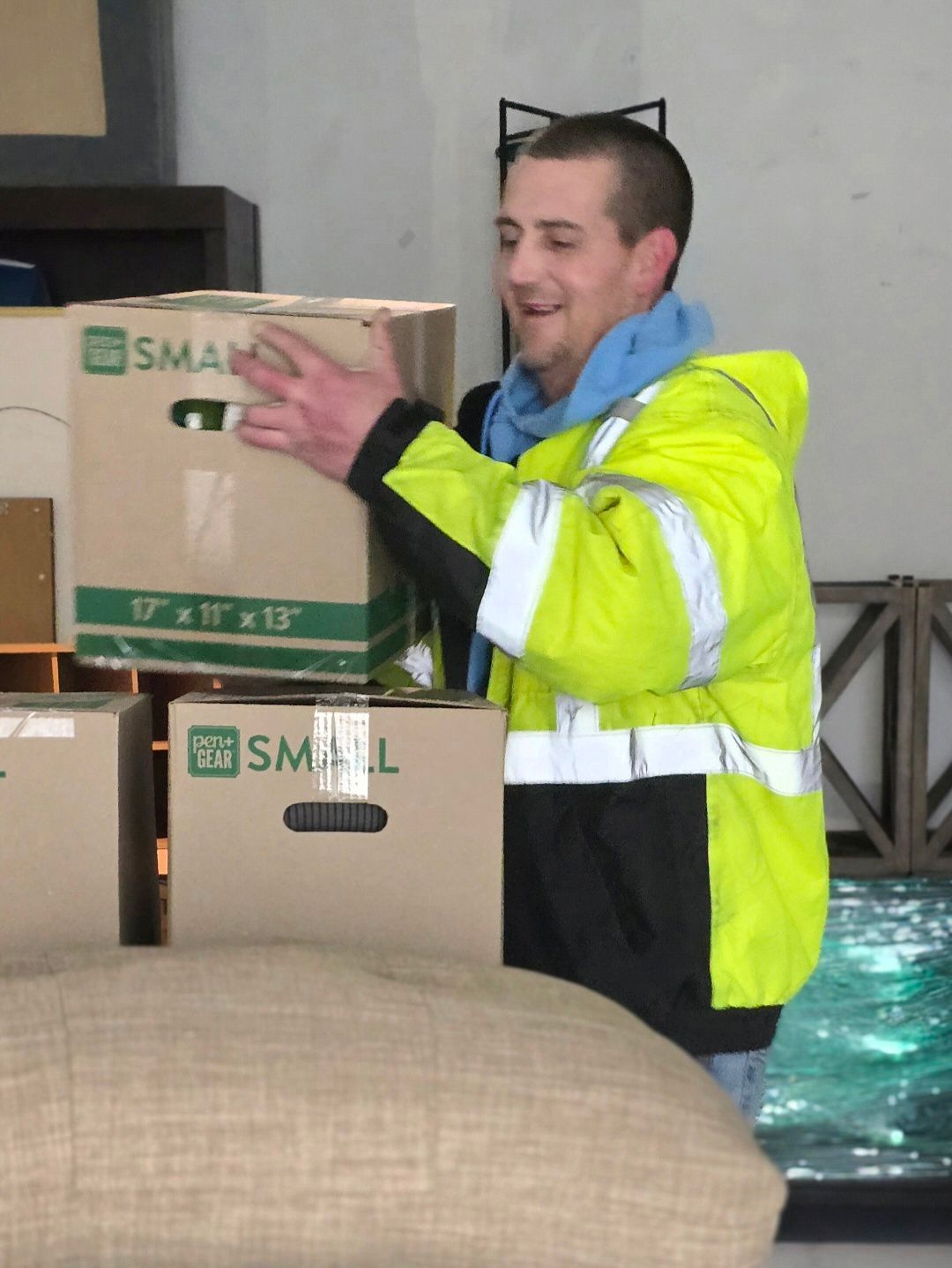 Jones Helps U Move crew member uniformed in JHUM safety jacket arranging boxes