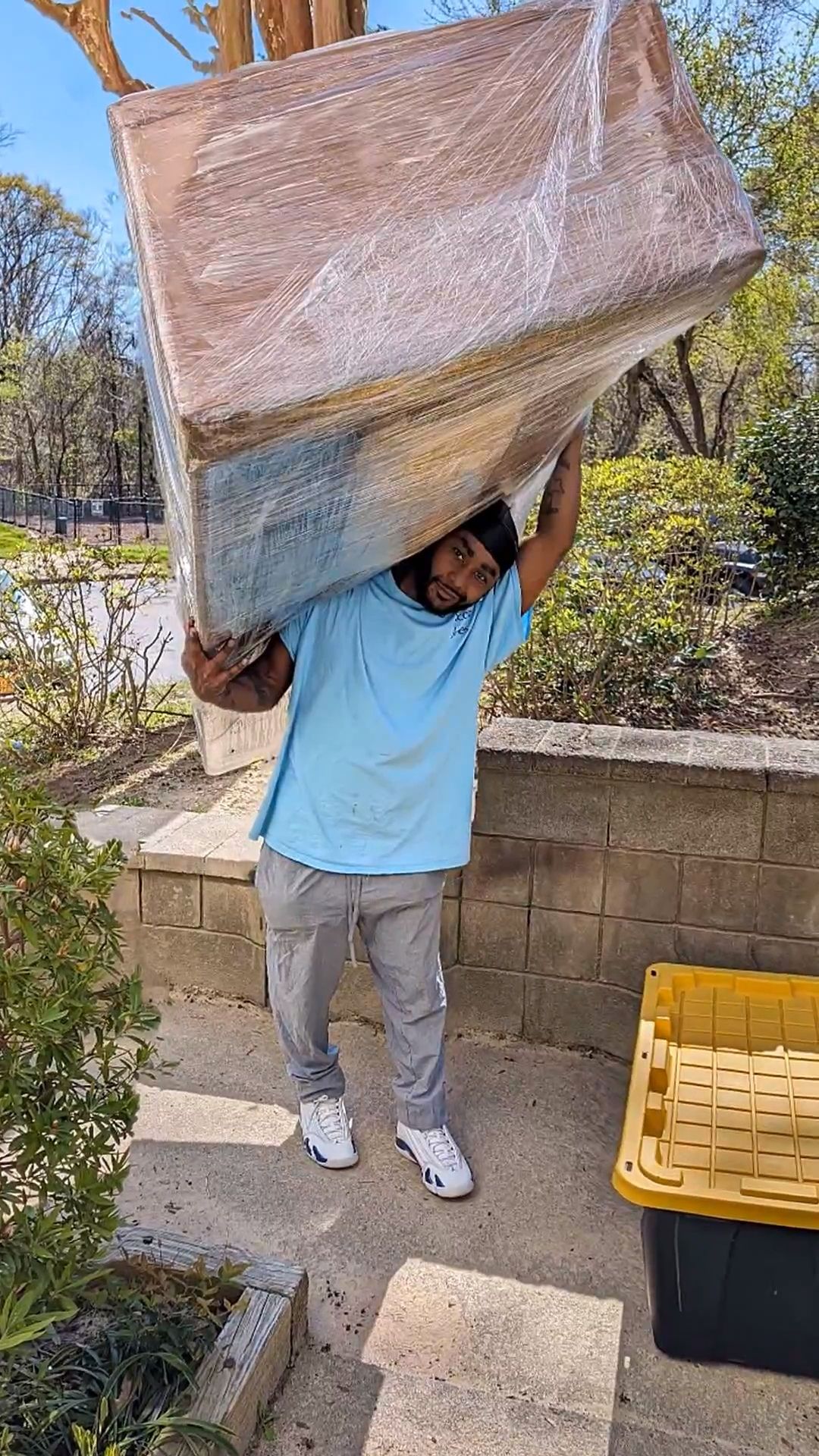 Employee Jay of Jones Helps U Move holding up a professionally wrapped couch