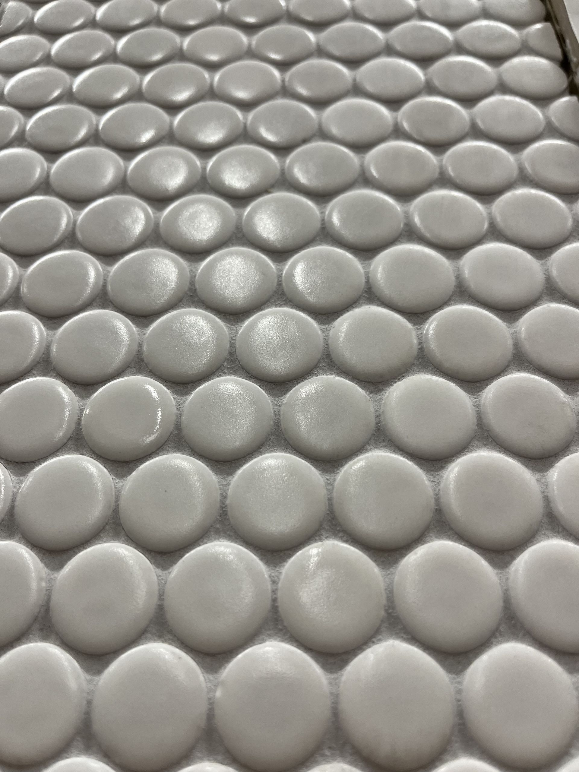 A close up of a white tile with circles on it.