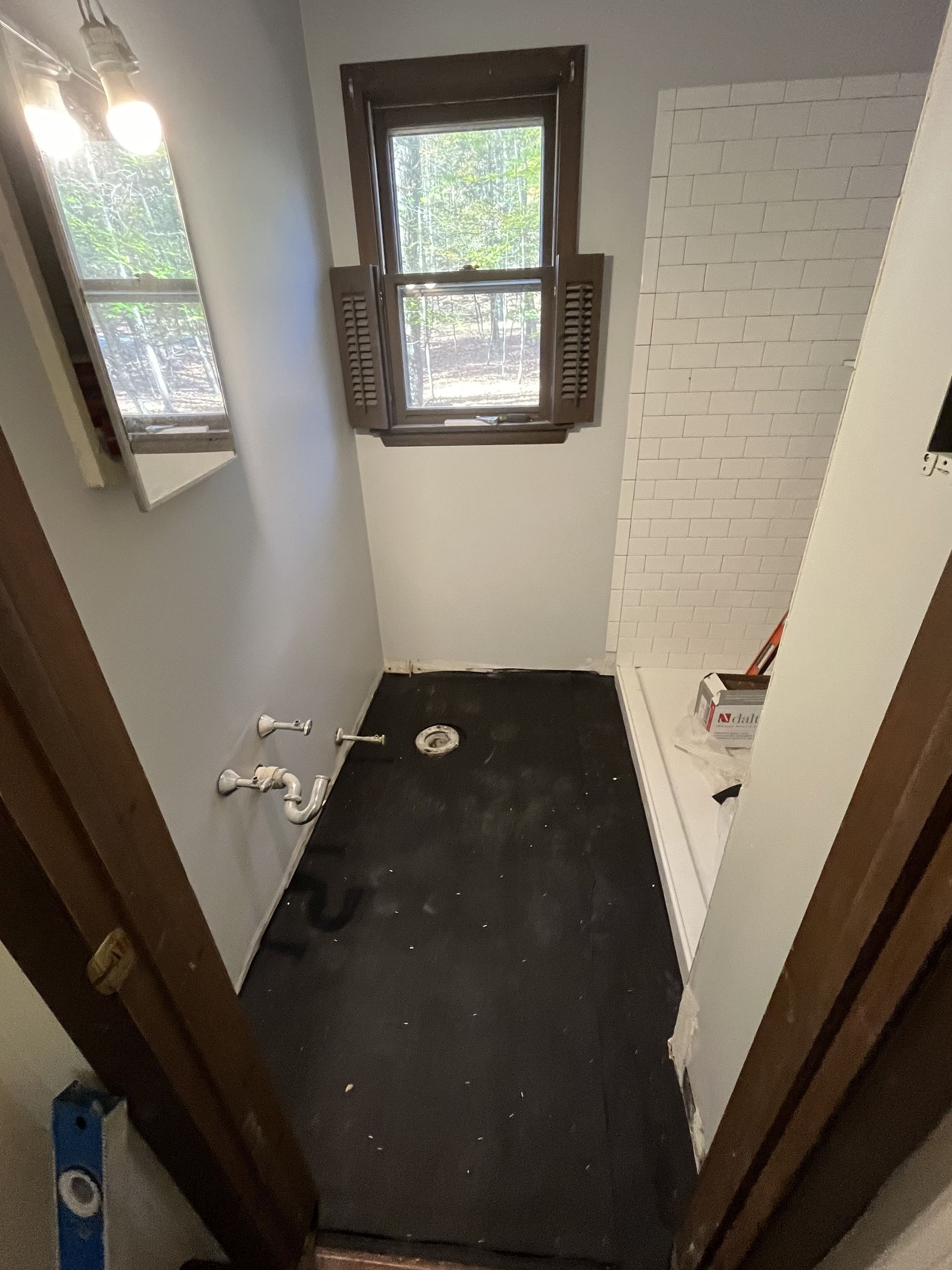 A bathroom with a black floor and a window.