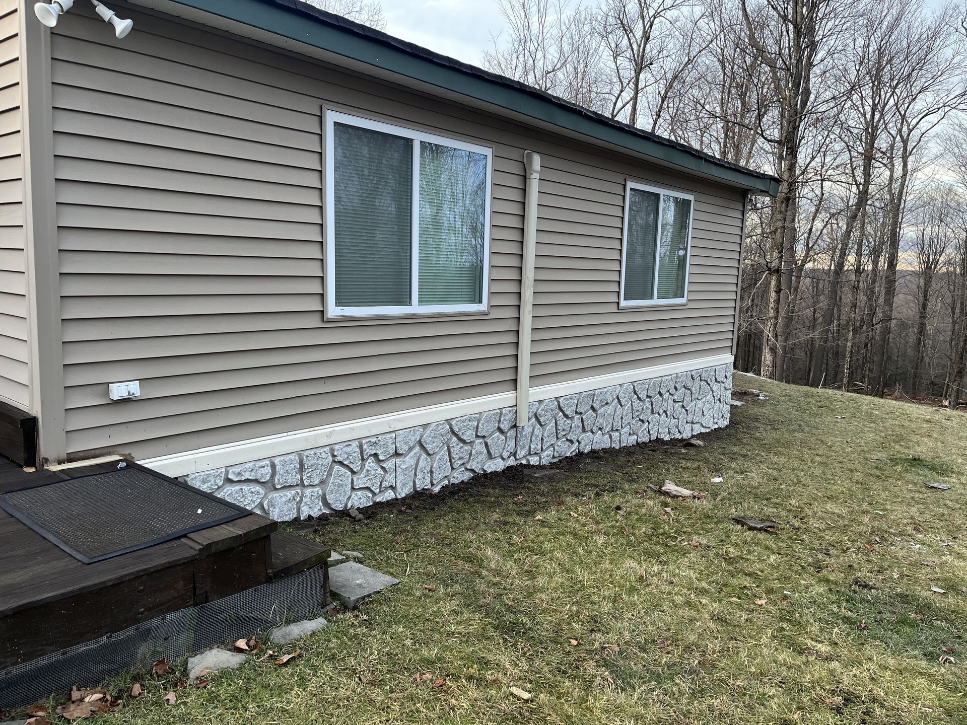 A mobile home is sitting on top of a grassy hill.