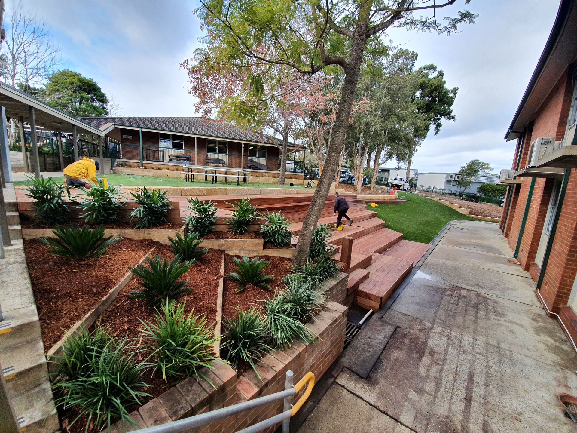 Landscaped outdoor area with terraced garden beds and building.