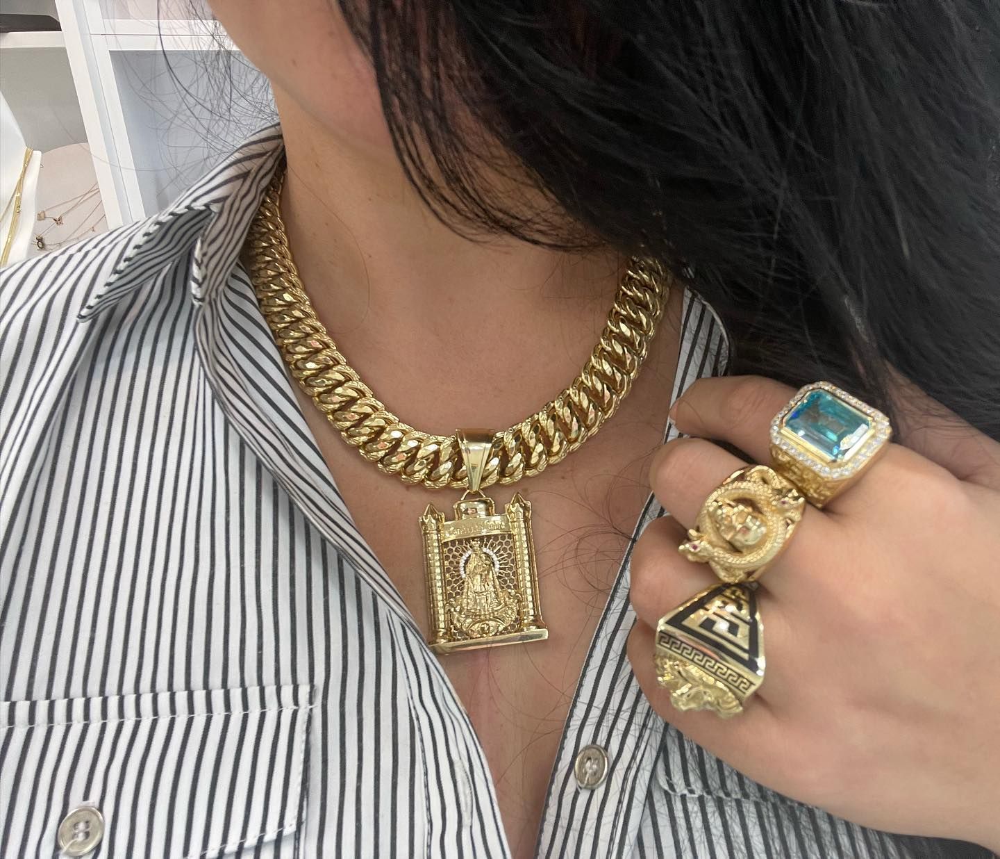 Una mujer que lleva un collar de cadena de oro y anillos. Yene Joyeria