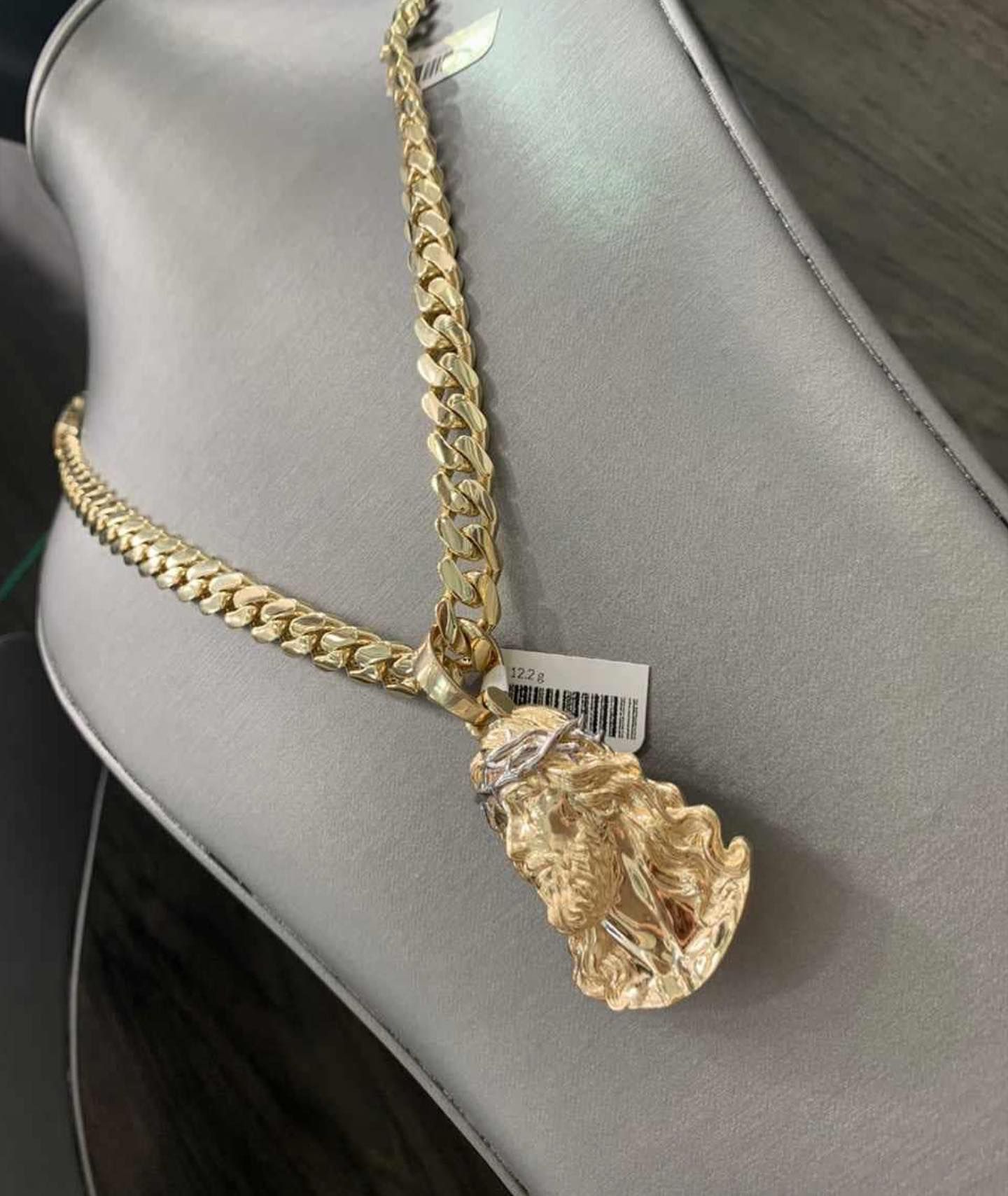 Un collar de oro con un colgante en un maniquí. Yene Joyeria