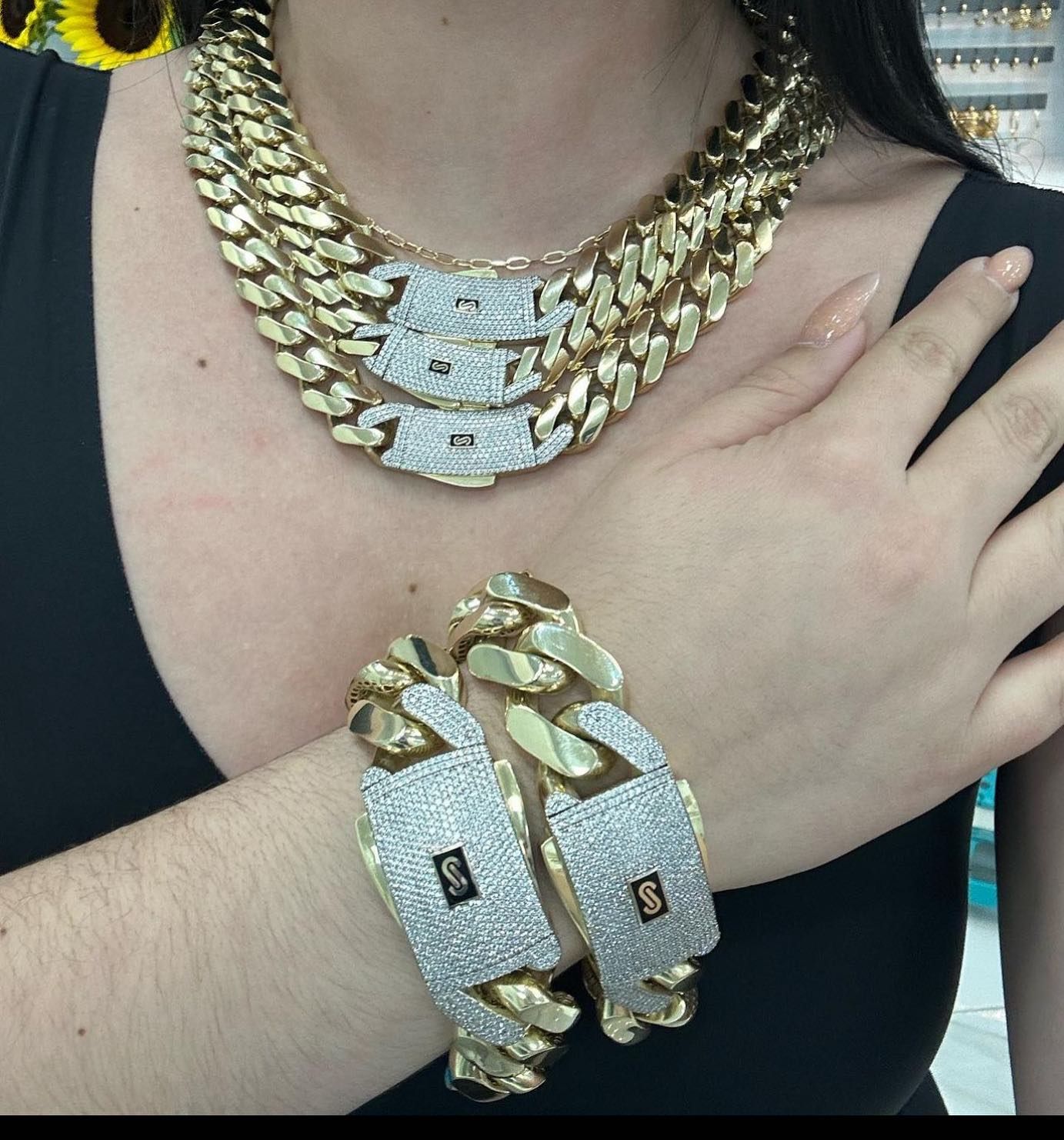 Una mujer que lleva un collar y una pulsera de cadena de oro. Yene Joyeria