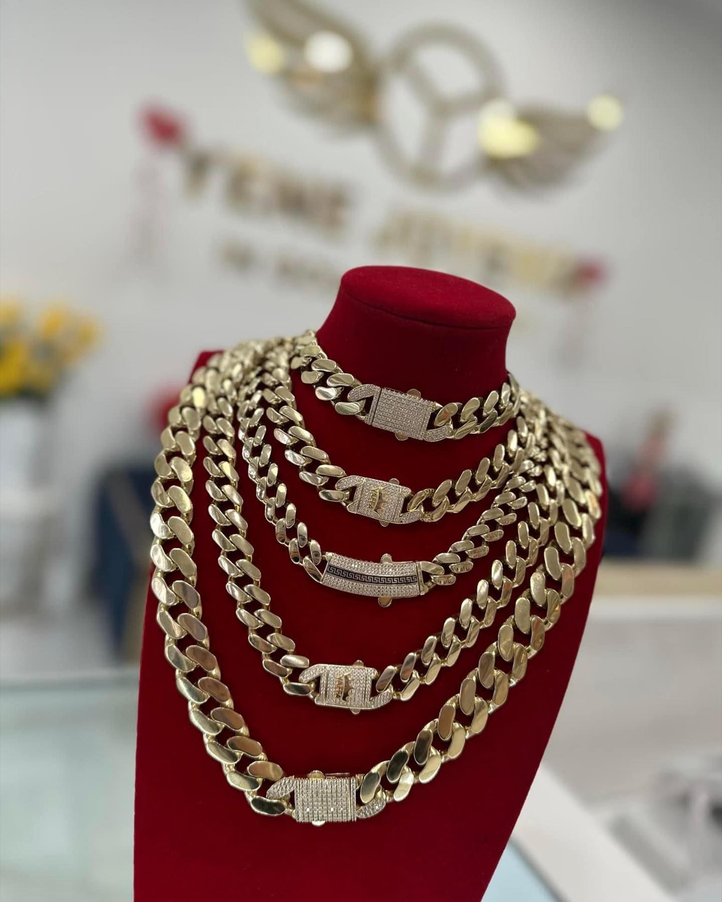 Varias cadenas de oro están apiladas una encima de otra sobre un maniquí. Yene Joyeria