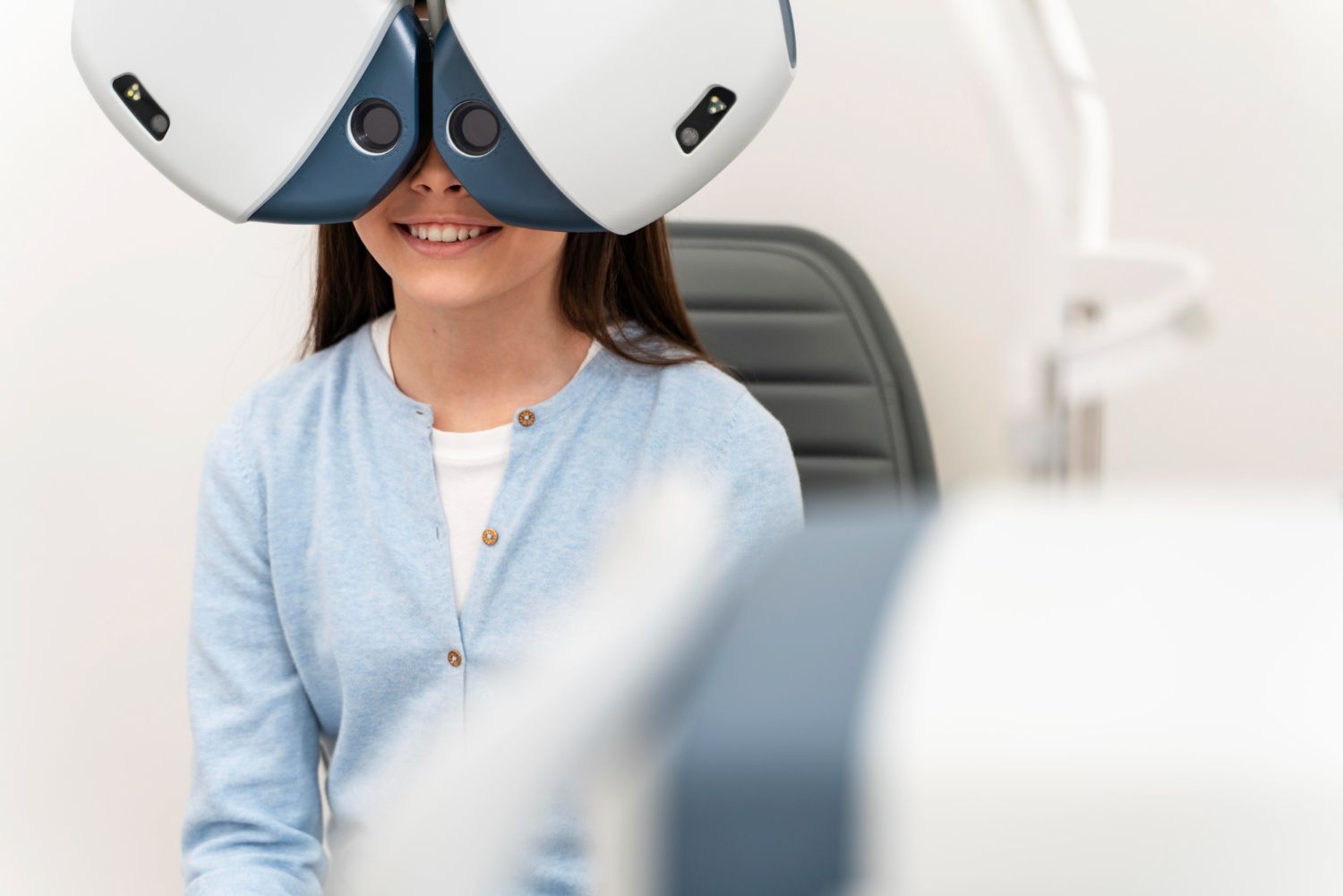 A young girl is having her eyes examined by an ophthalmologist.