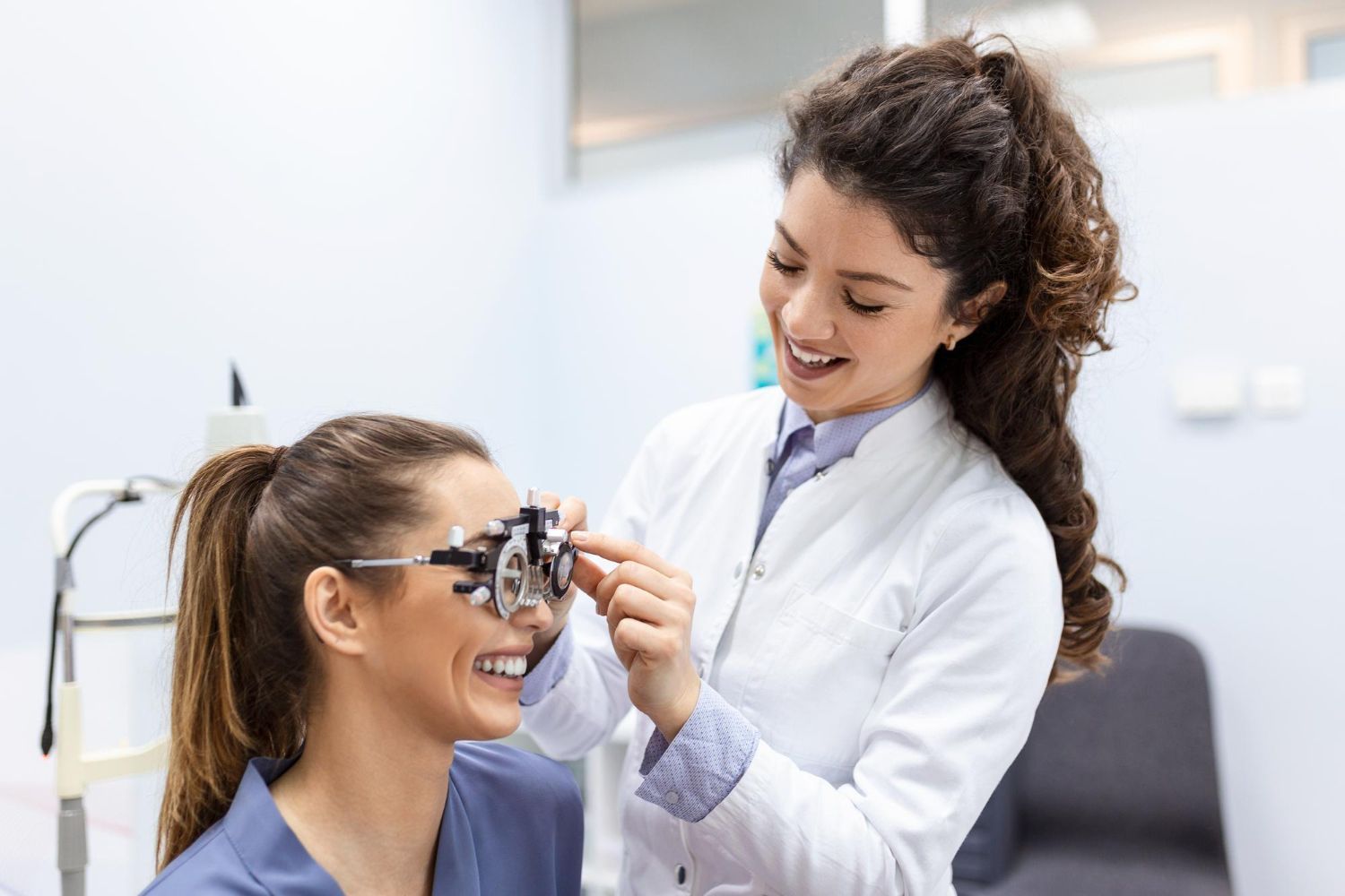 An ophthalmologist is examining a patient 's eye with a phoropter.