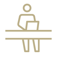 A line drawing of a person sitting at a desk with a laptop.