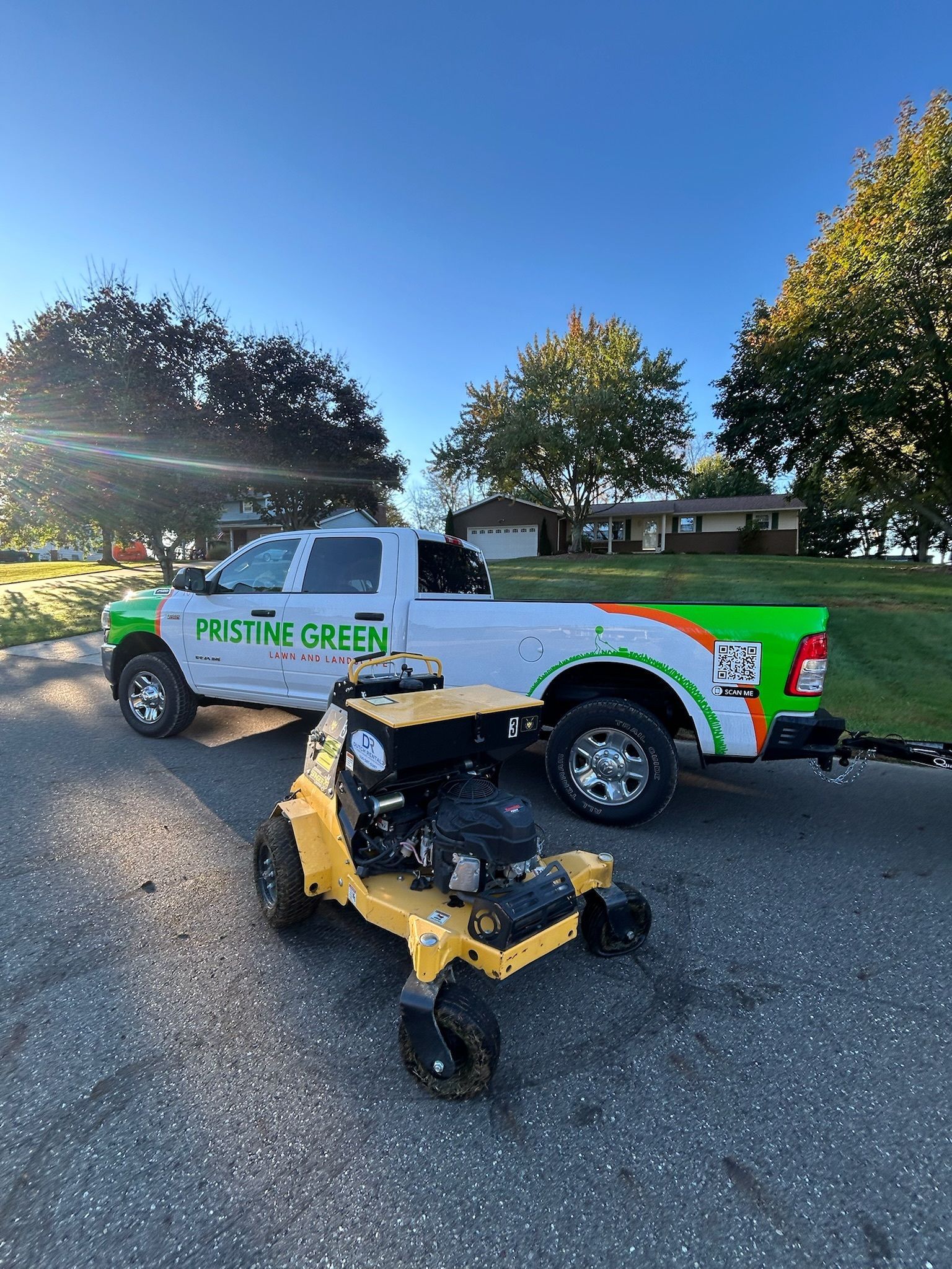 White truck and yellow lawn machine with 
