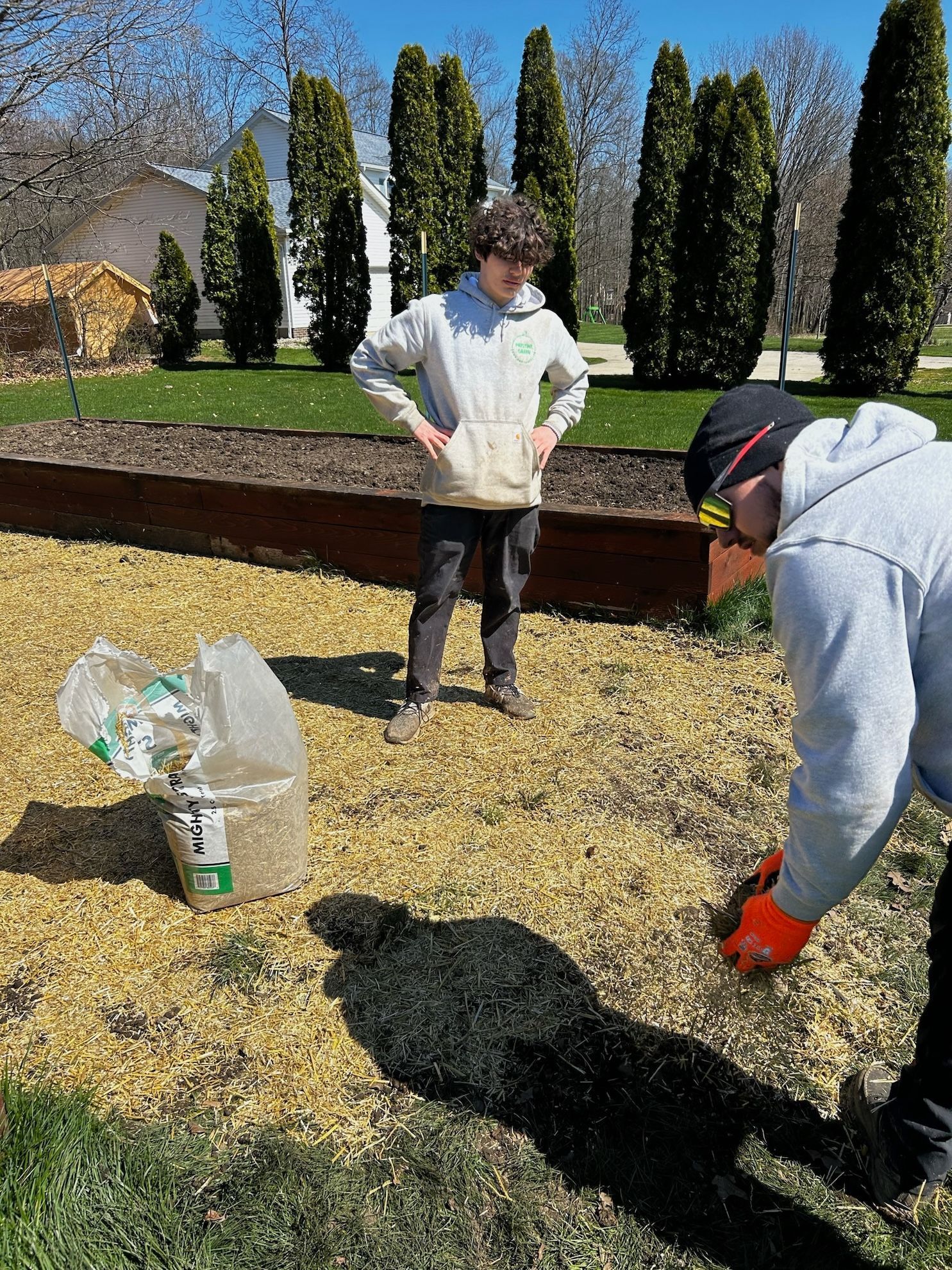 A man and a woman are working in a garden.