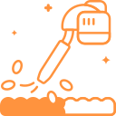 An orange leaf blower spraying debris from a surface.