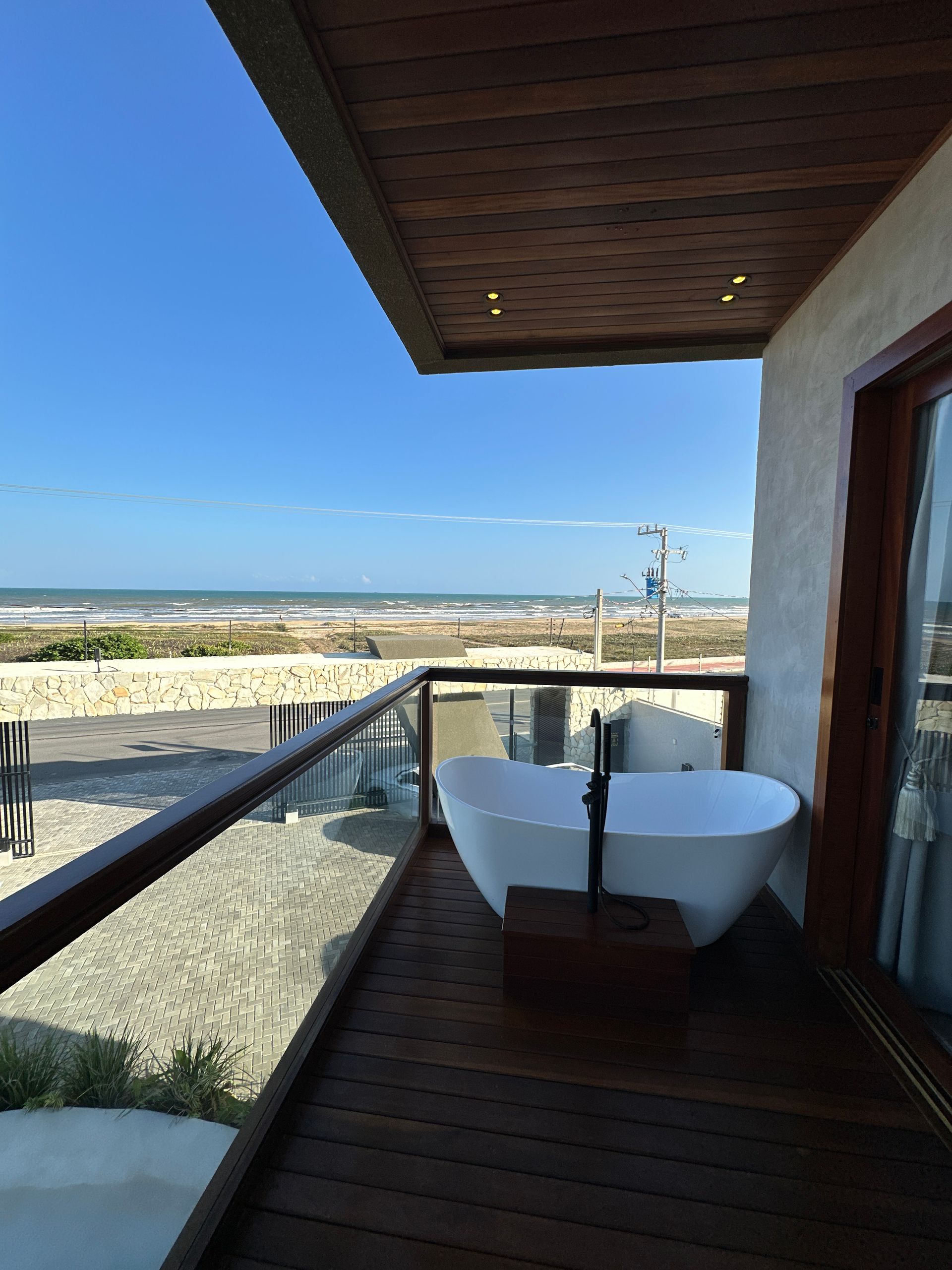 Uma varanda com banheira e vista para o oceano