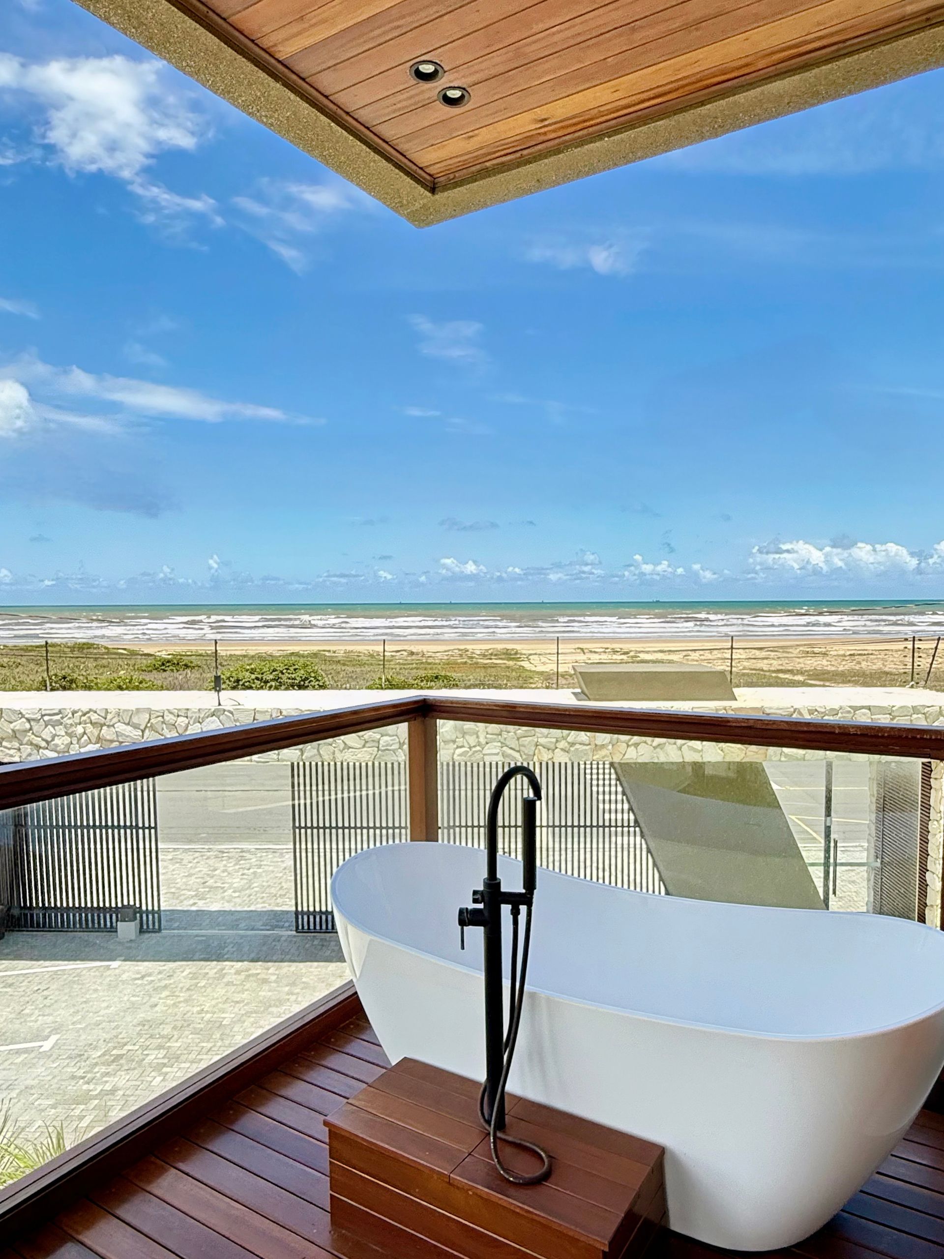 Uma banheira em uma varanda com vista para o oceano.